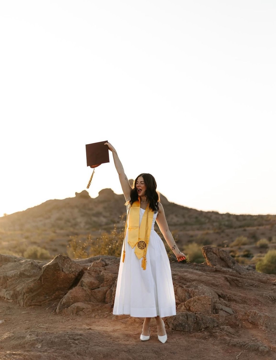 College graduation celebration portrait in Arizona with cap toss during sunset outdoor photography session