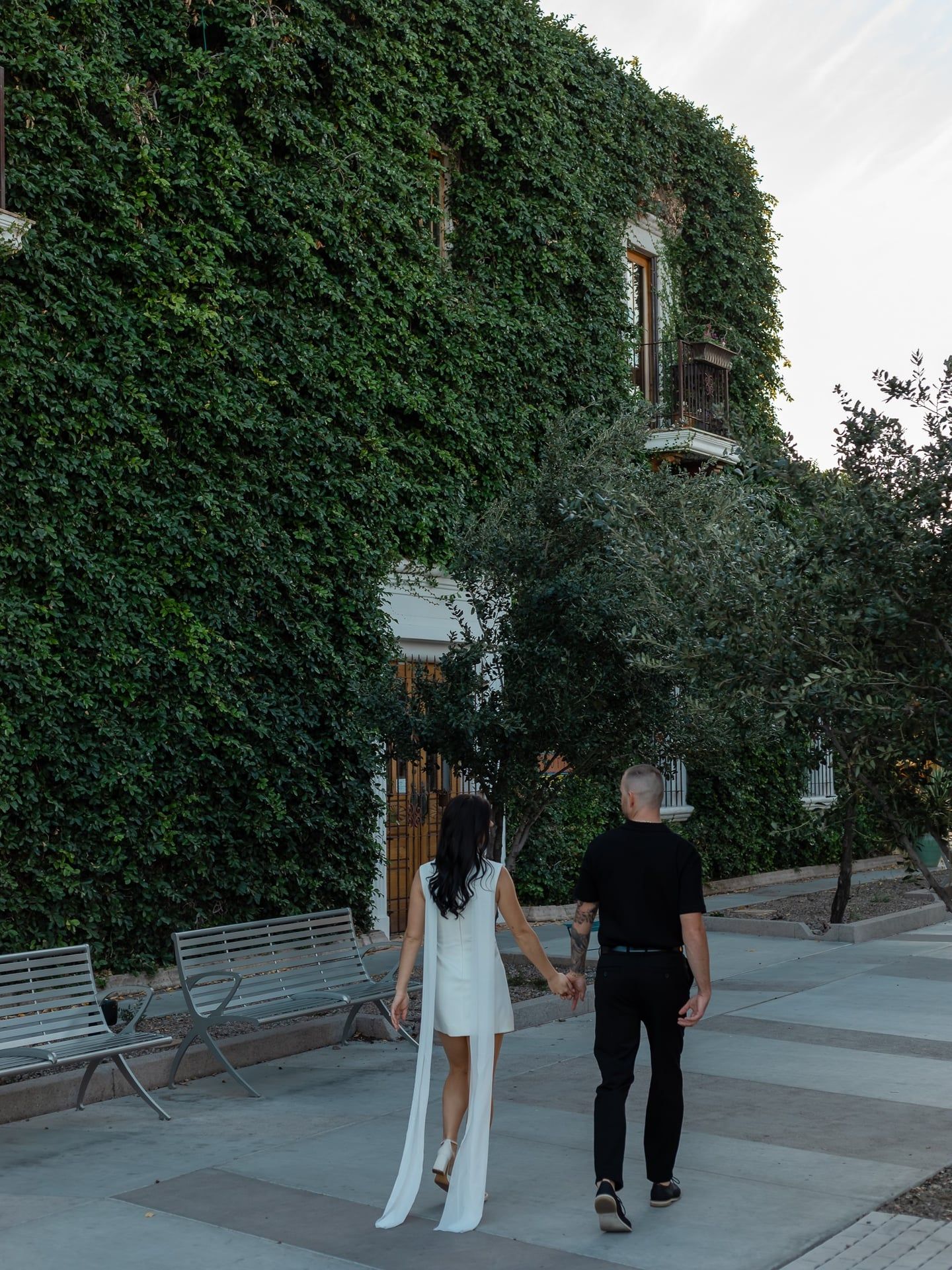 Romantic engagement portrait of couple in Scottsdale Arizona with green ivy covered building