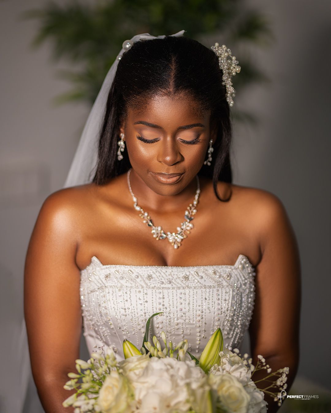 Elegant Black bride in a white wedding dress holding a floral bouquet, captured in soft light, showcasing bridal beauty, romance, and timele