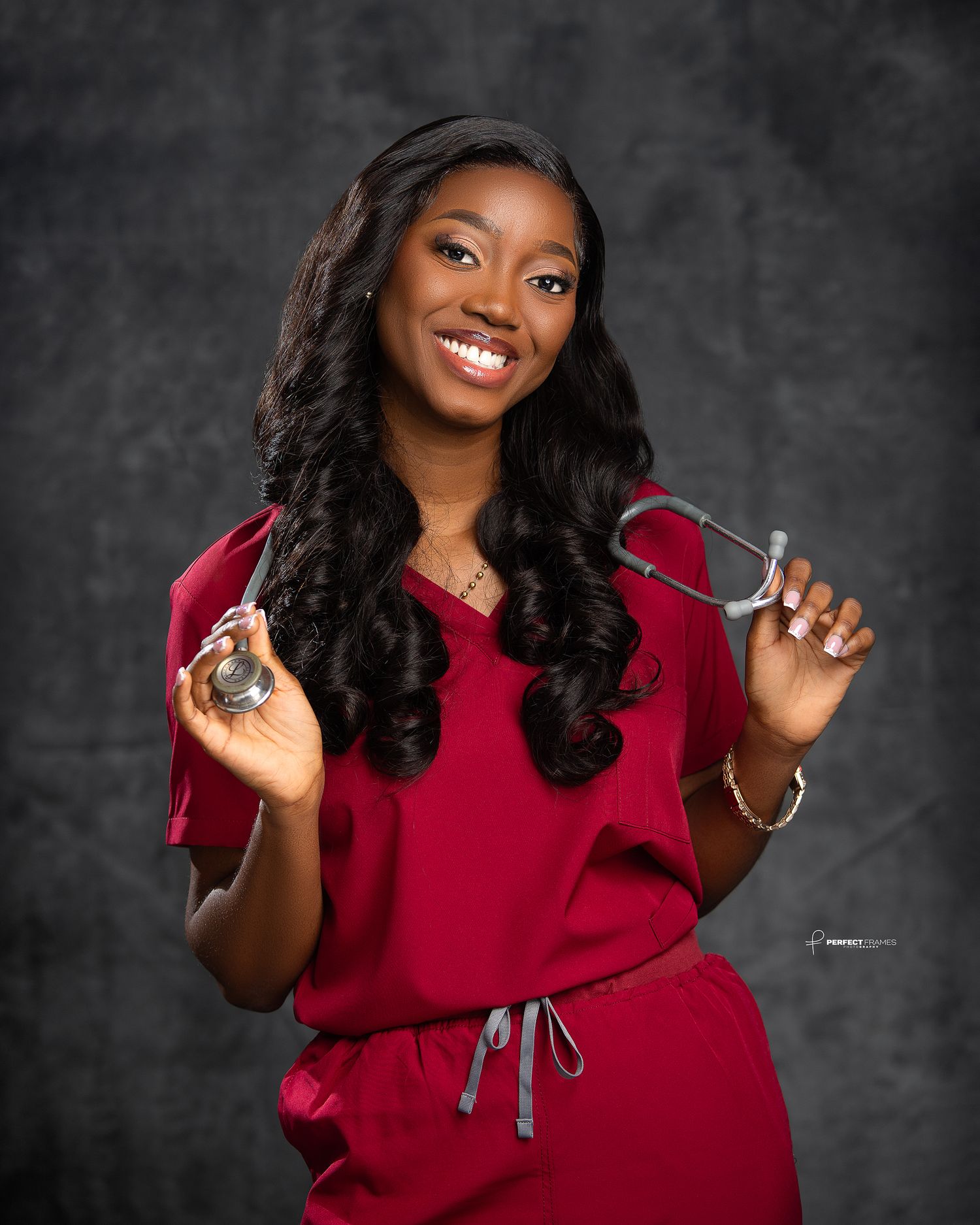 Professional portrait of a smiling female healthcare professional in scrubs holding a stethoscope, showcasing confidence, care, and medical