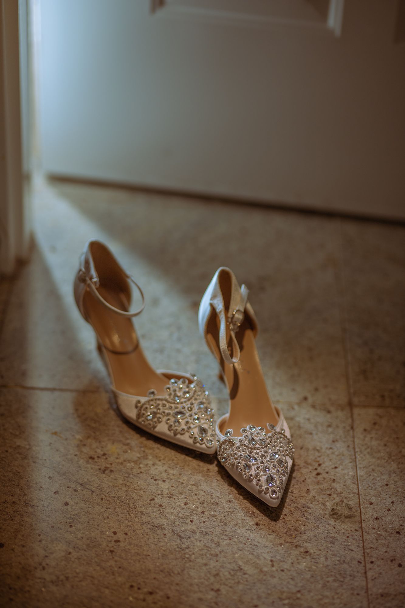 bride shoes Elegant golden wedding detail photo featuring bridal heels, wedding rings, and groom’s watch, capturing timeless luxur