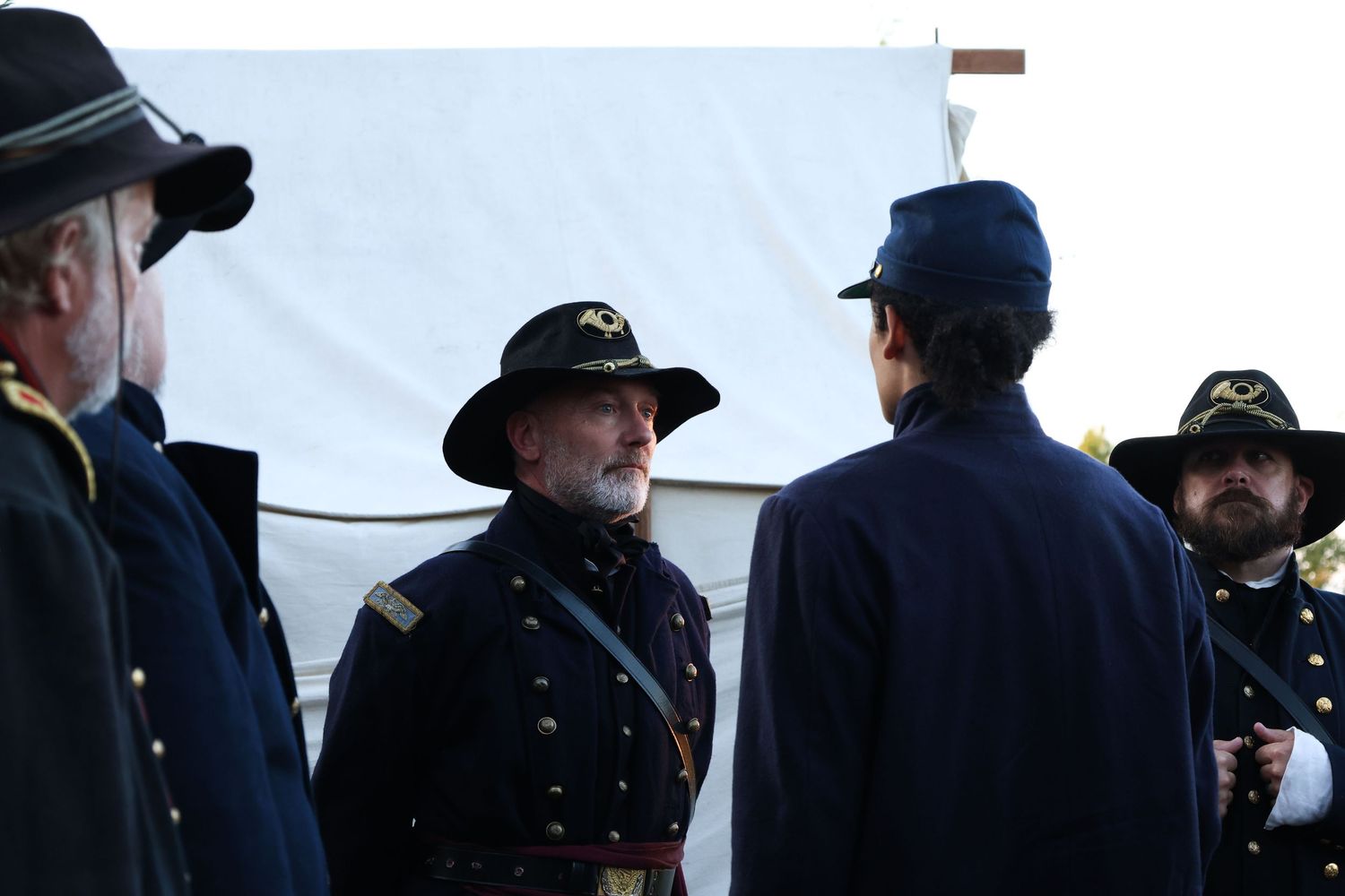Civil War reenactors in blue Union army uniforms stand in formation during a historical demonstration.