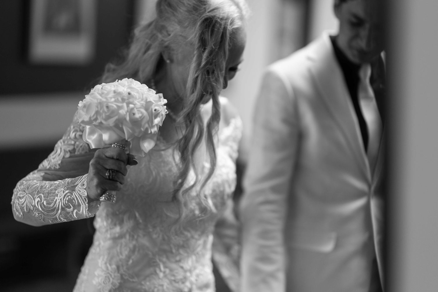 Black and white photo collage showing emotional moments from a wedding ceremony with embraces and celebrations.