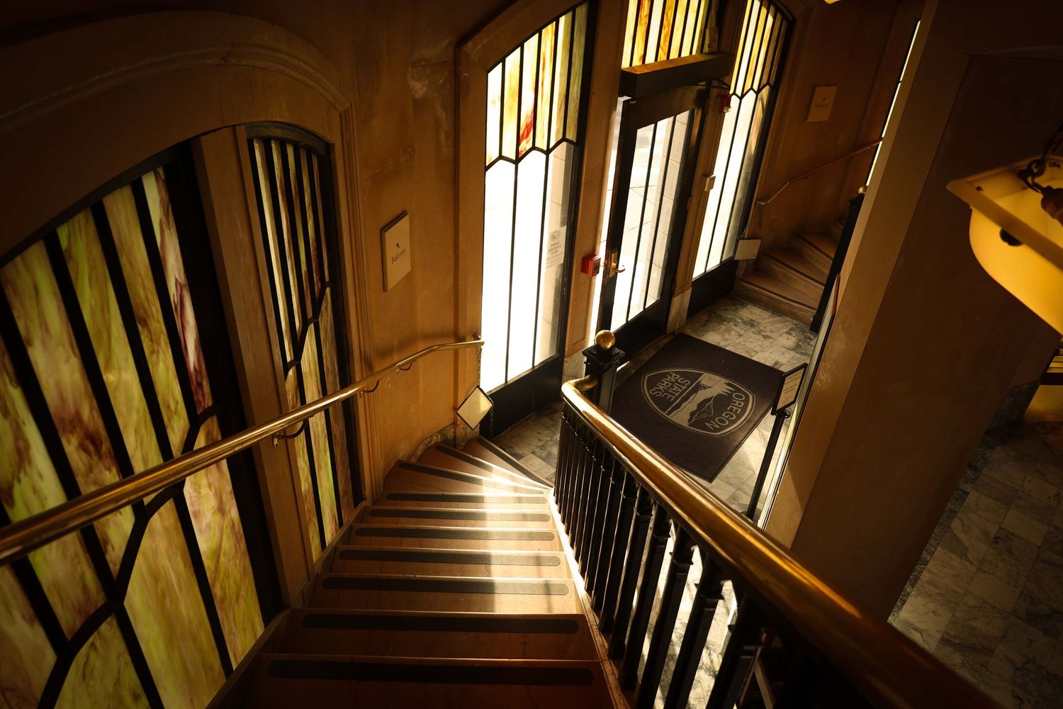 Interior stairwell of an old prison with dramatic lighting and metal railings.