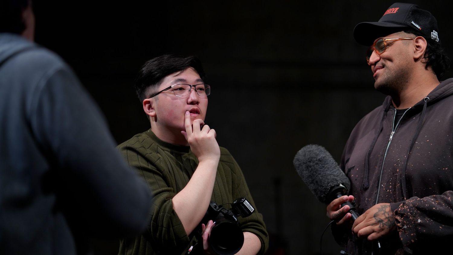 Behind the scenes photo of film crew members discussing during production shoot.
