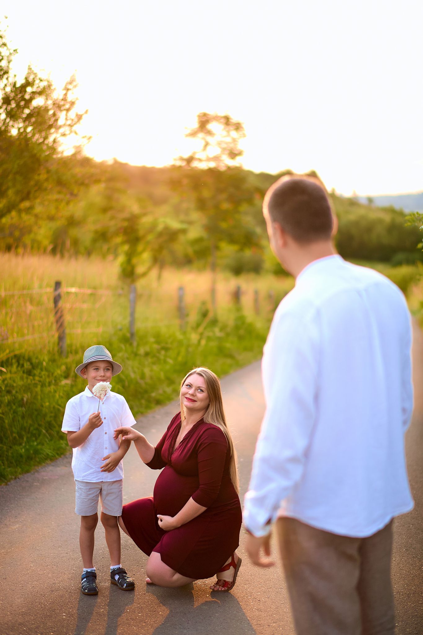 Candid family interaction on a dirt path during sunset with mountains in background.