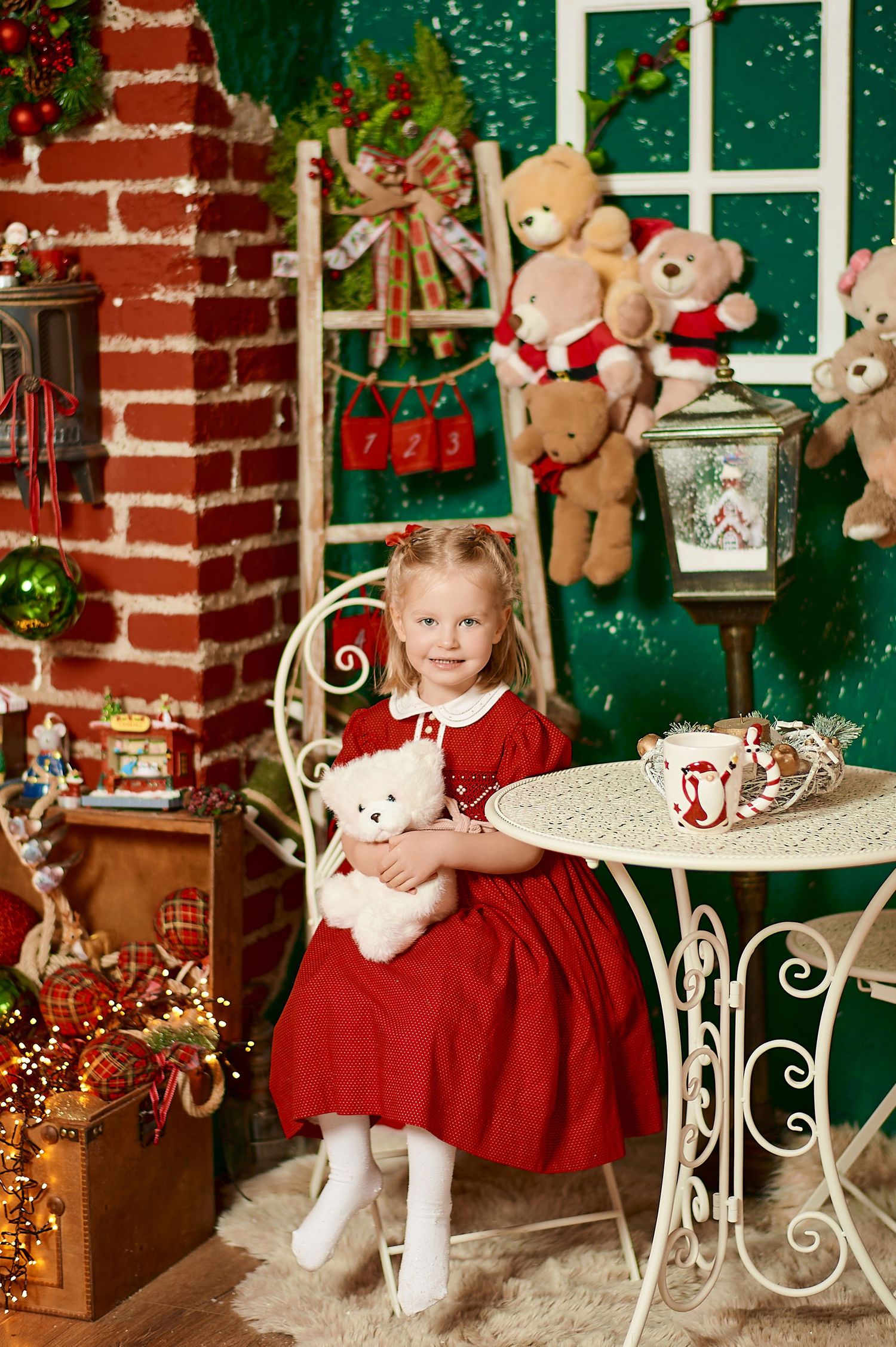 Young girl in red dress holds white teddy bear in festive Christmas-themed room with toys and holiday decorations.