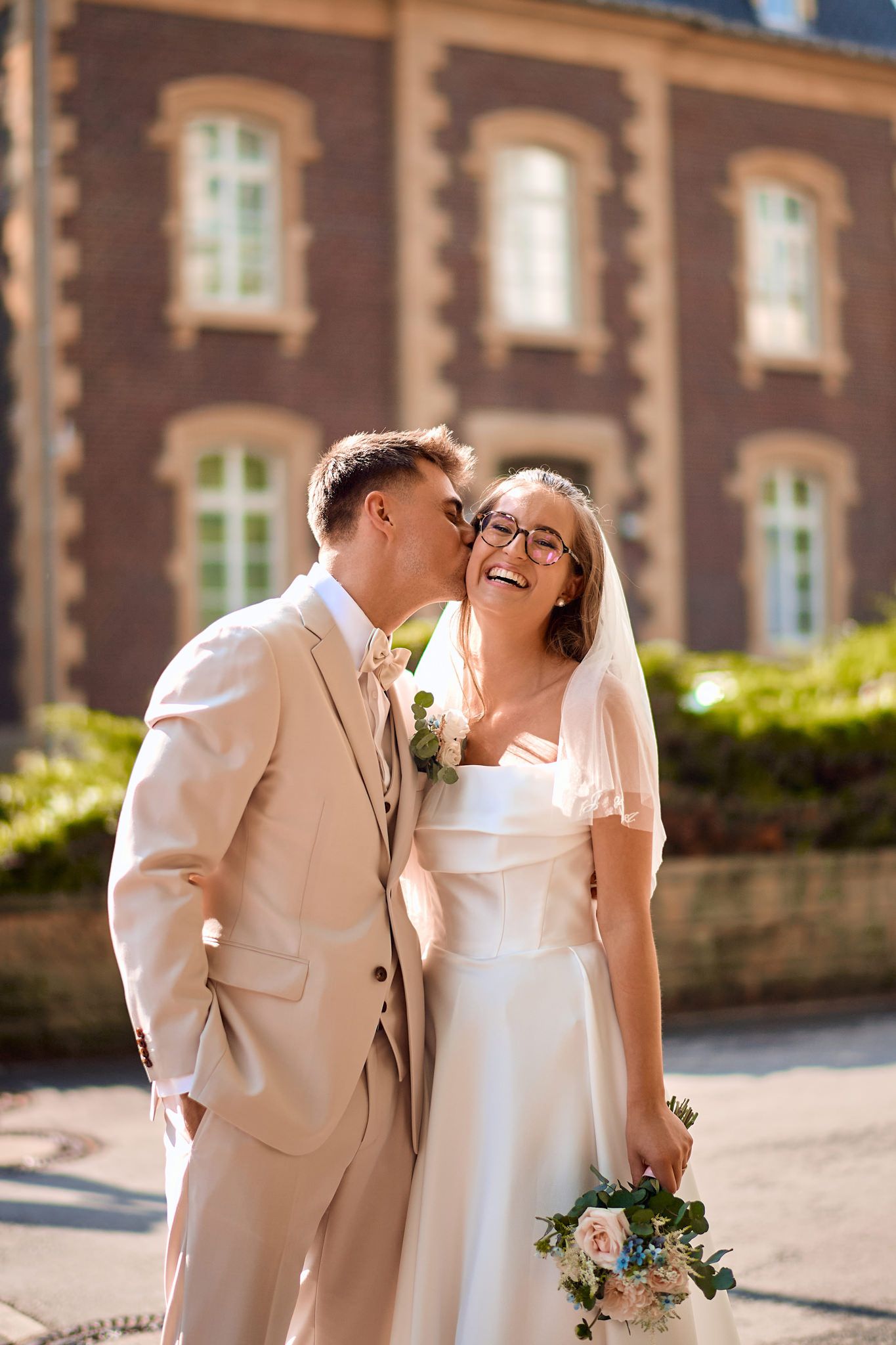 Romantic wedding portraits captured against a classic brick building exterior.