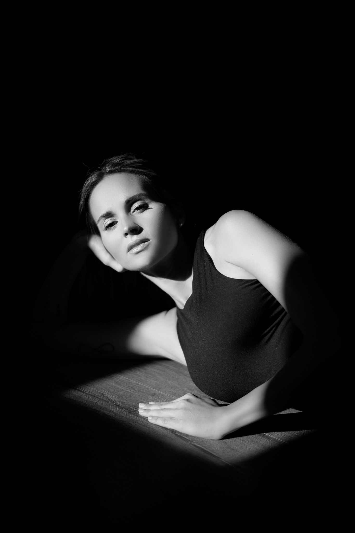 Dramatic black and white portrait series featuring artistic poses in dark lighting.