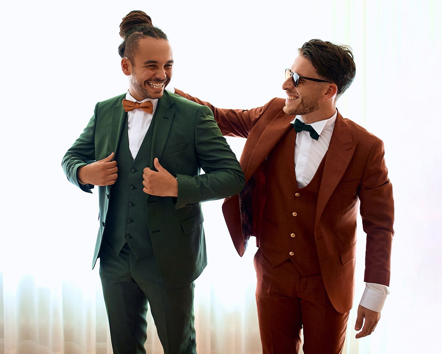 Wedding party members in formal attire interacting playfully in a modern studio setting.
