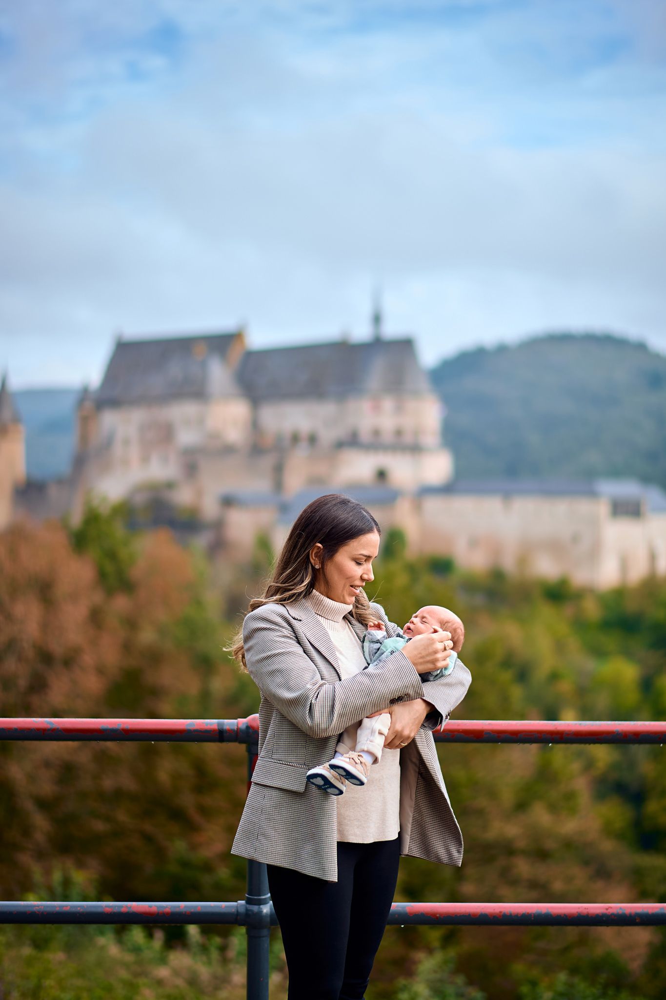 Candid family moment captured with majestic castle architecture in background.