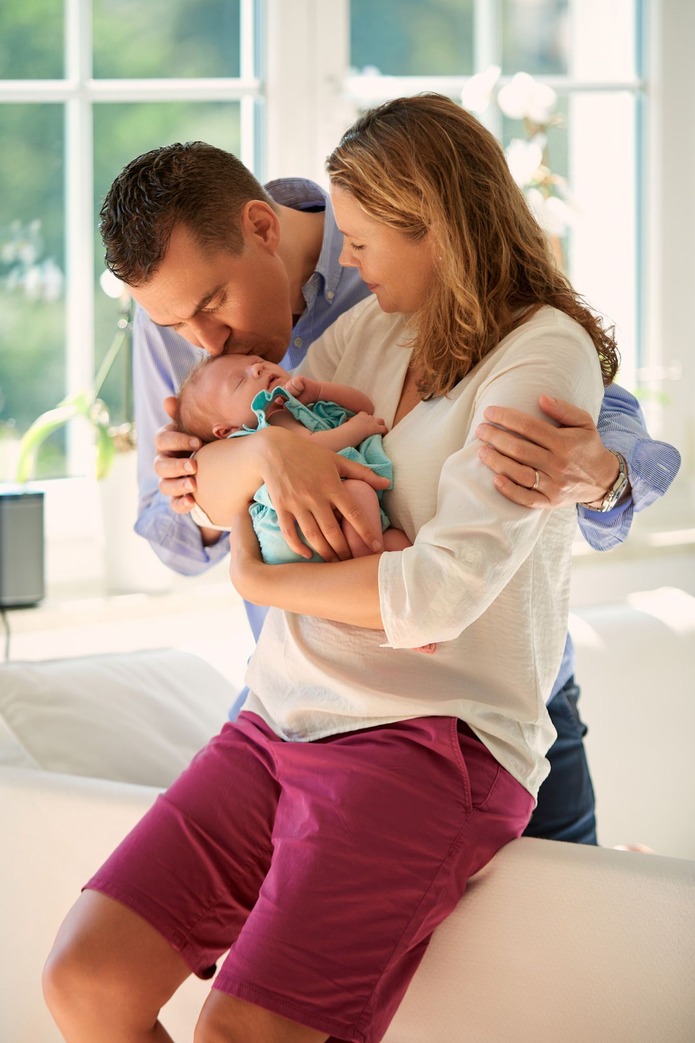 Intimate indoor photoshoot of couple in casual attire showing affection.