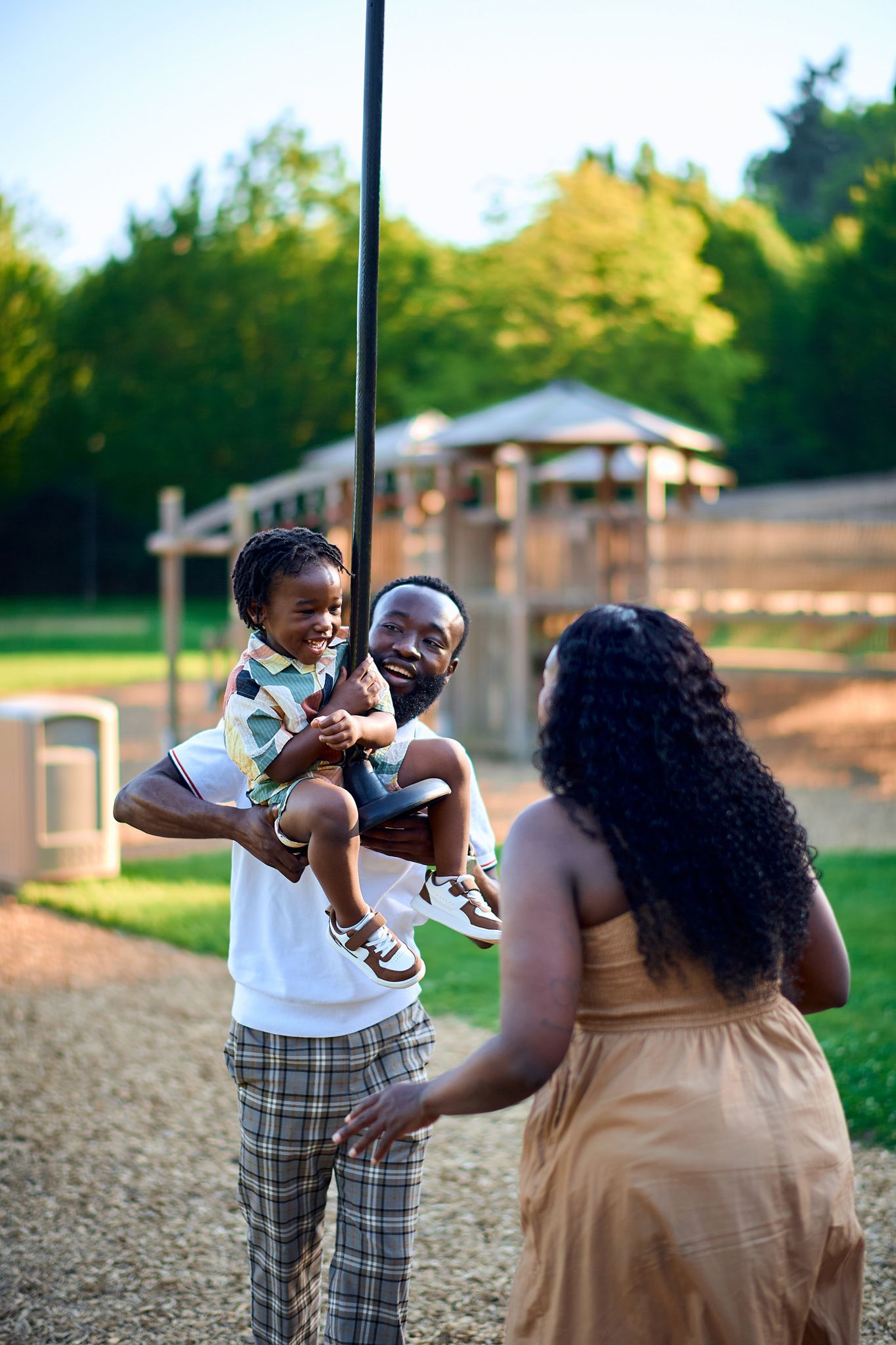 A tender family moment captured outdoors during golden hour in a natural setting.