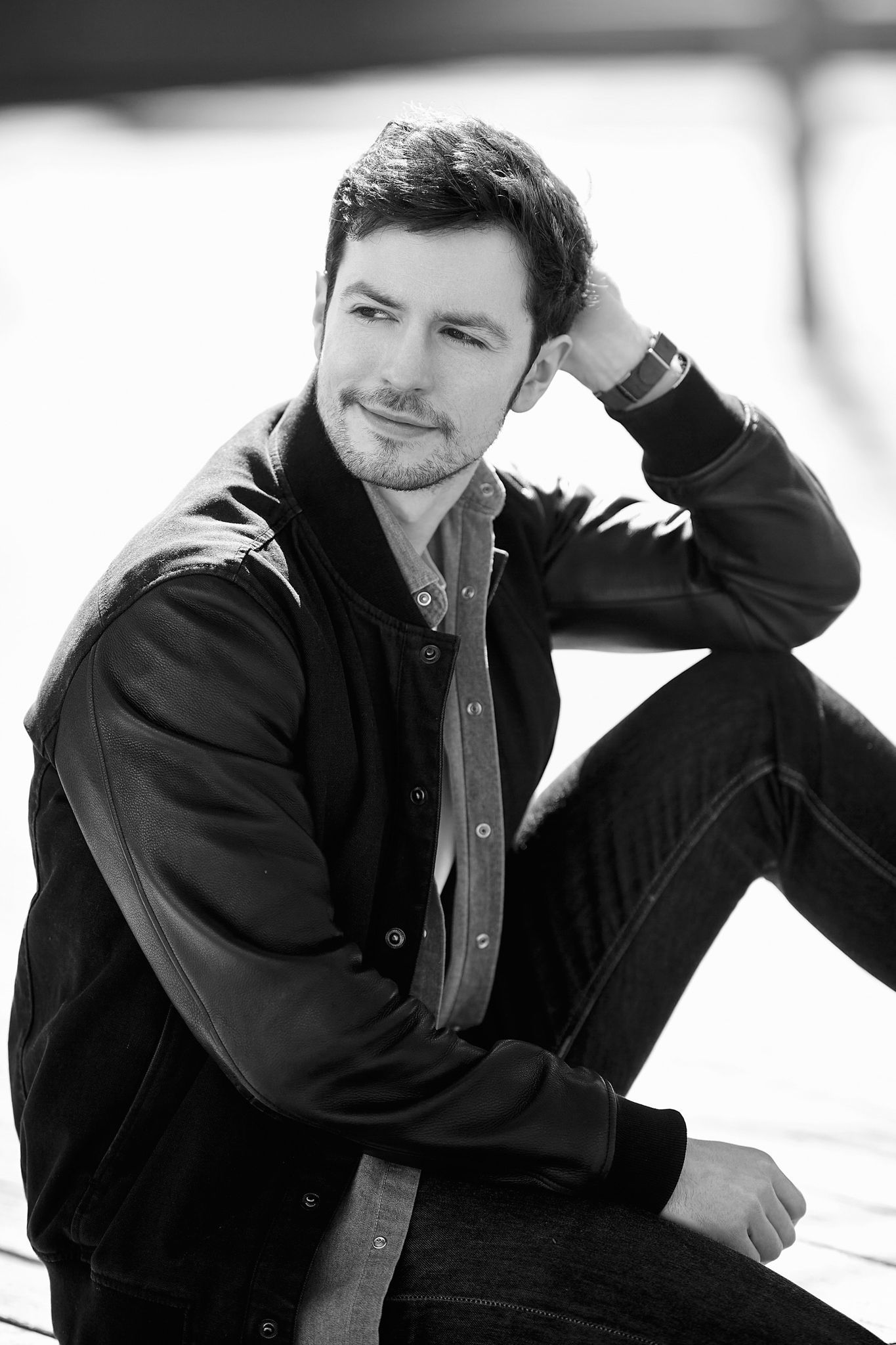 Black and white portrait series showing casual poses against white background.