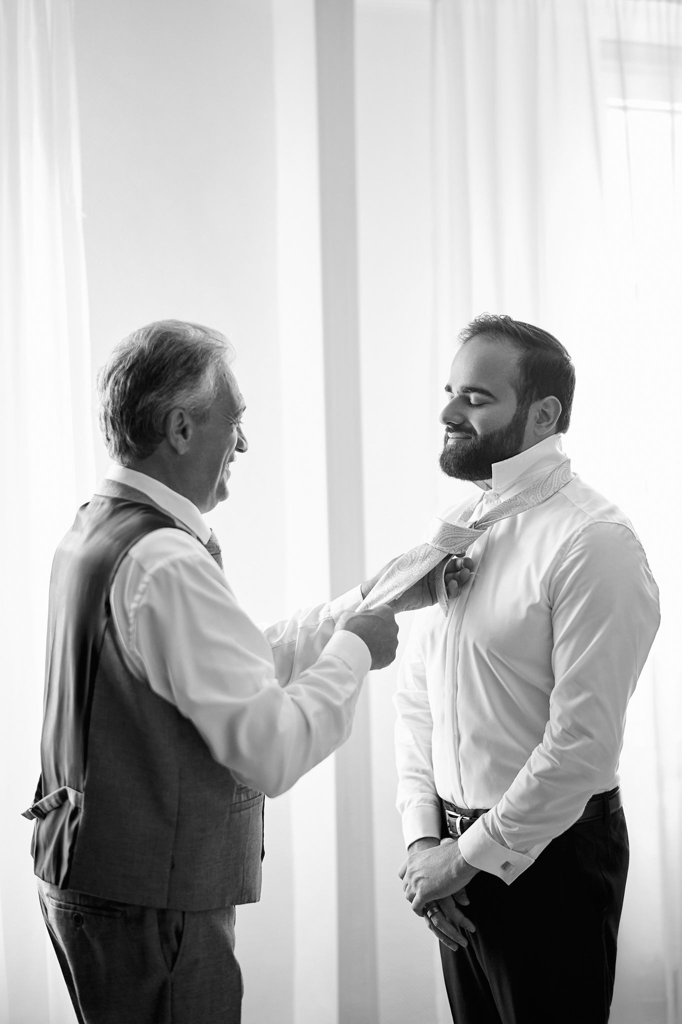 A sequence of black and white photos showing groomsmen adjusting their ties and getting ready.
