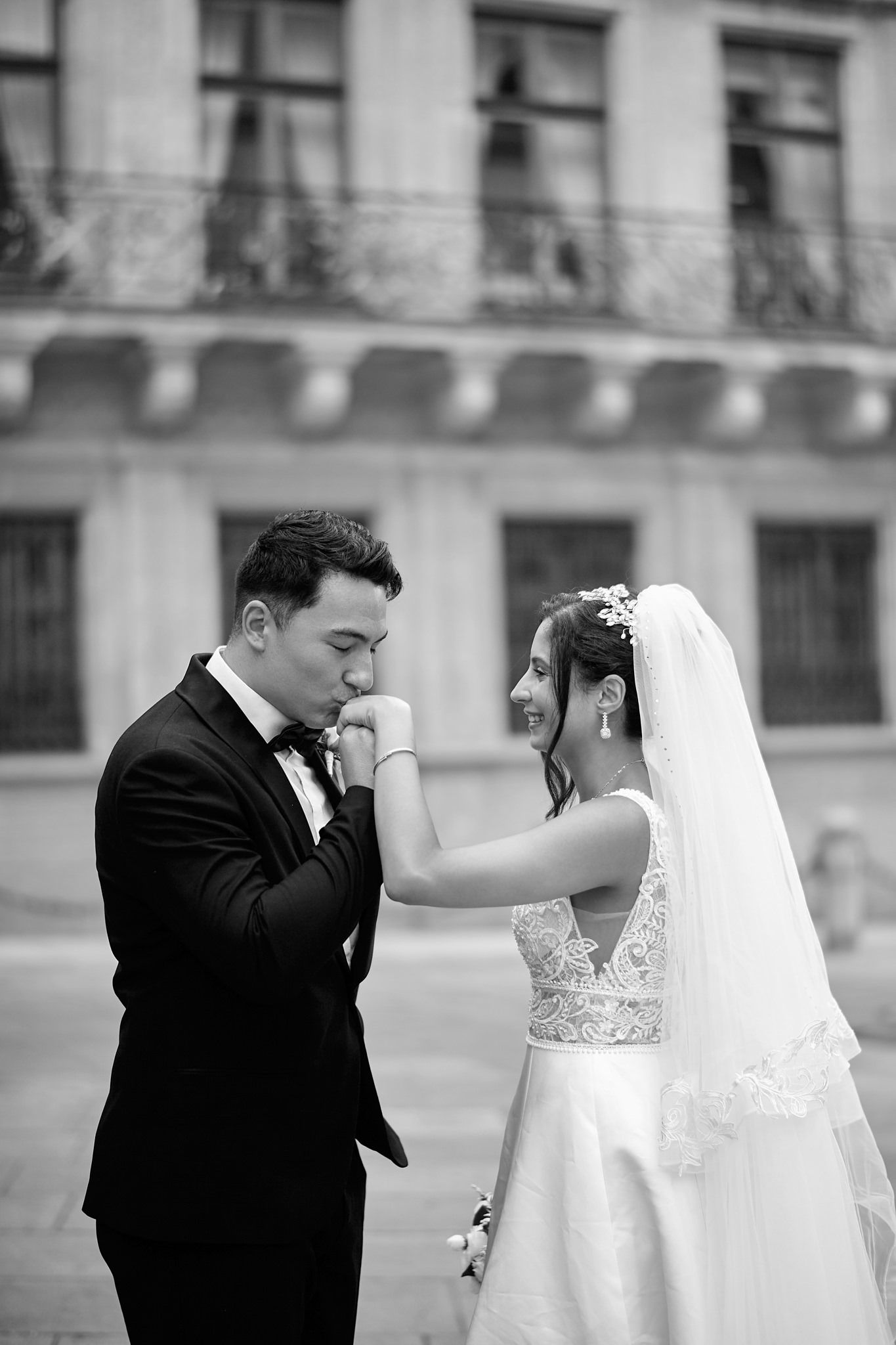 A series of black and white wedding portraits capturing romantic moments against an architectural backdrop.
