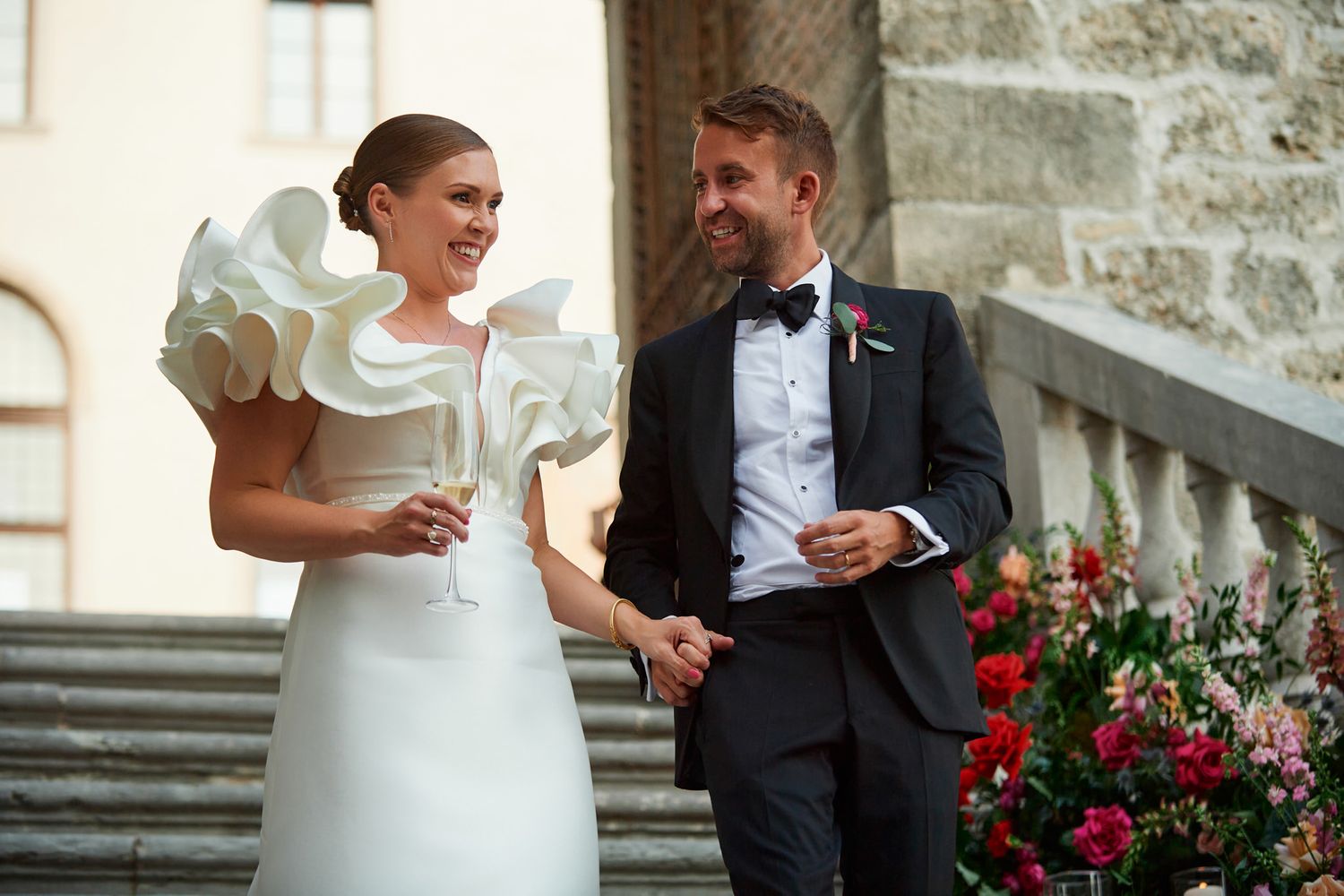 Elegant couple sharing candid moments in formal wedding attire.