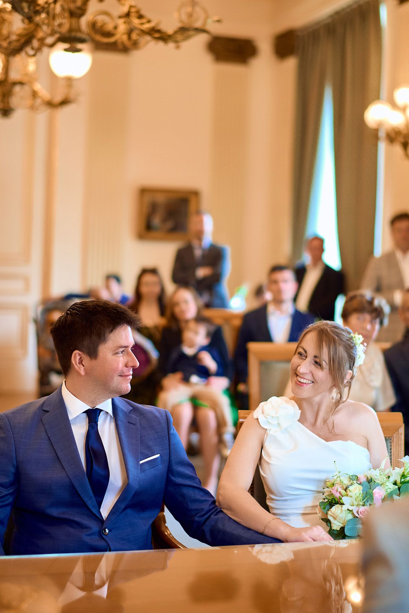 Wedding couple shares tender moments at an elegant reception venue with chandeliers.