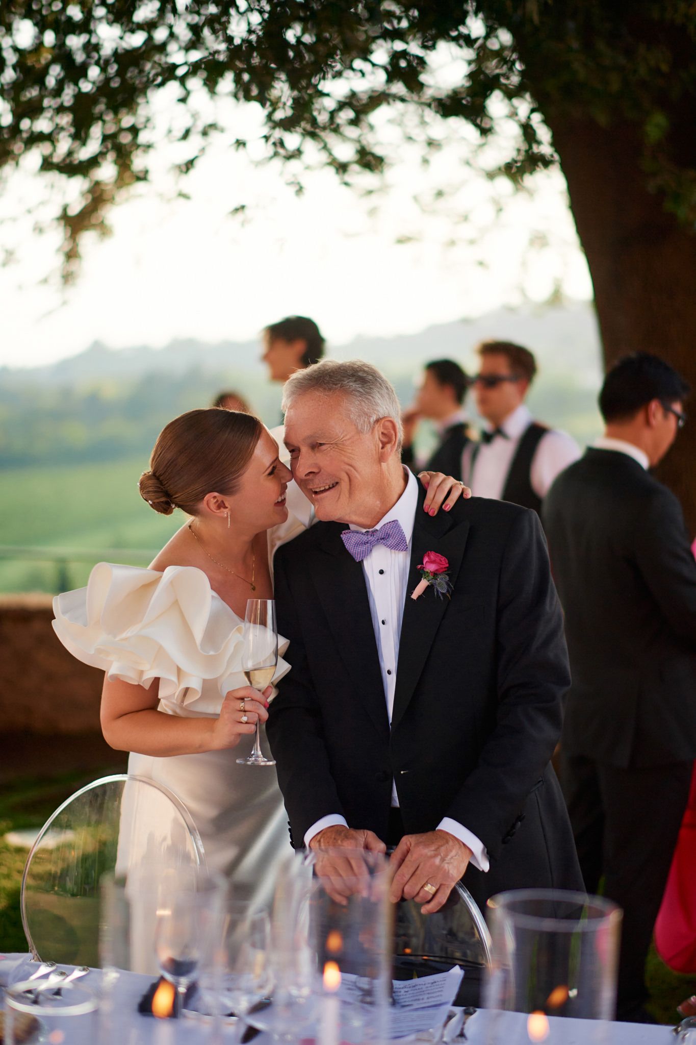 Intimate moment shared during an outdoor wedding reception with countryside views.