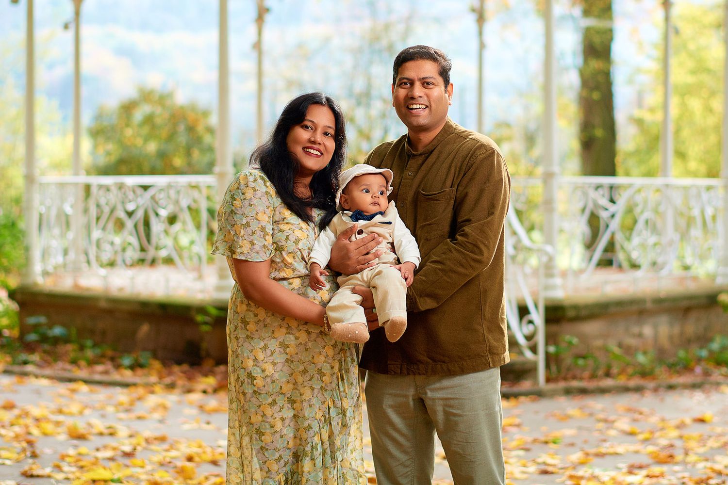 Family enjoying autumn moments together in a scenic outdoor setting with fallen leaves.