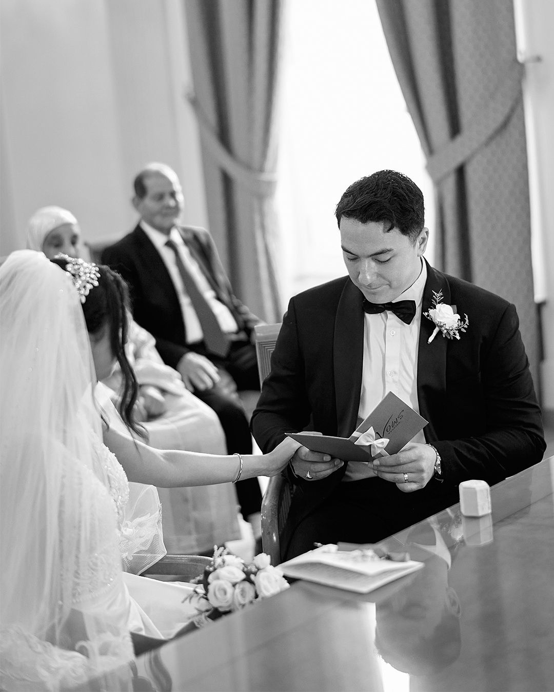 Black and white photo series of a couple signing marriage documents at a table.