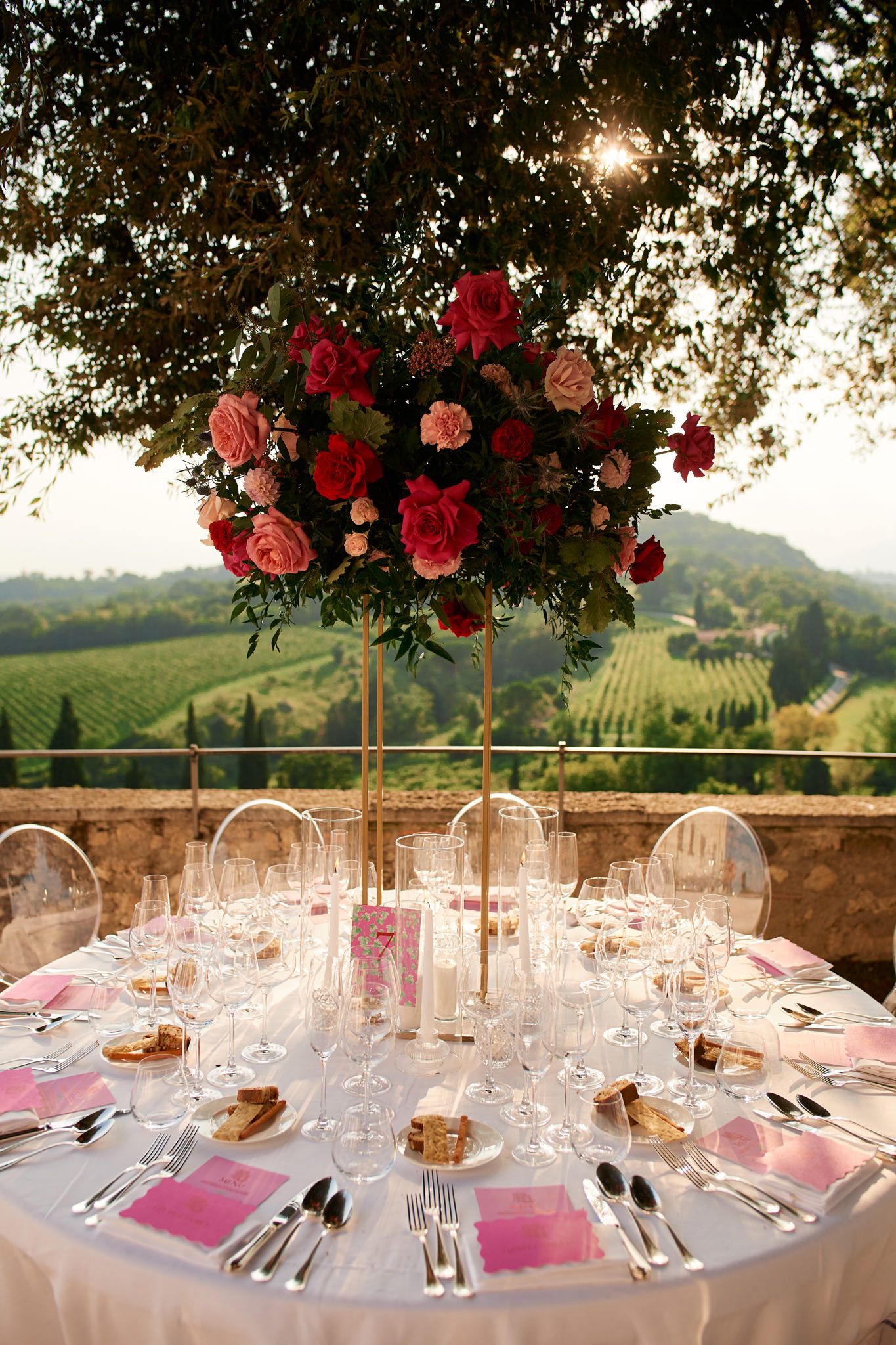 Elegant outdoor wedding reception table with pink accents and stunning vineyard views.