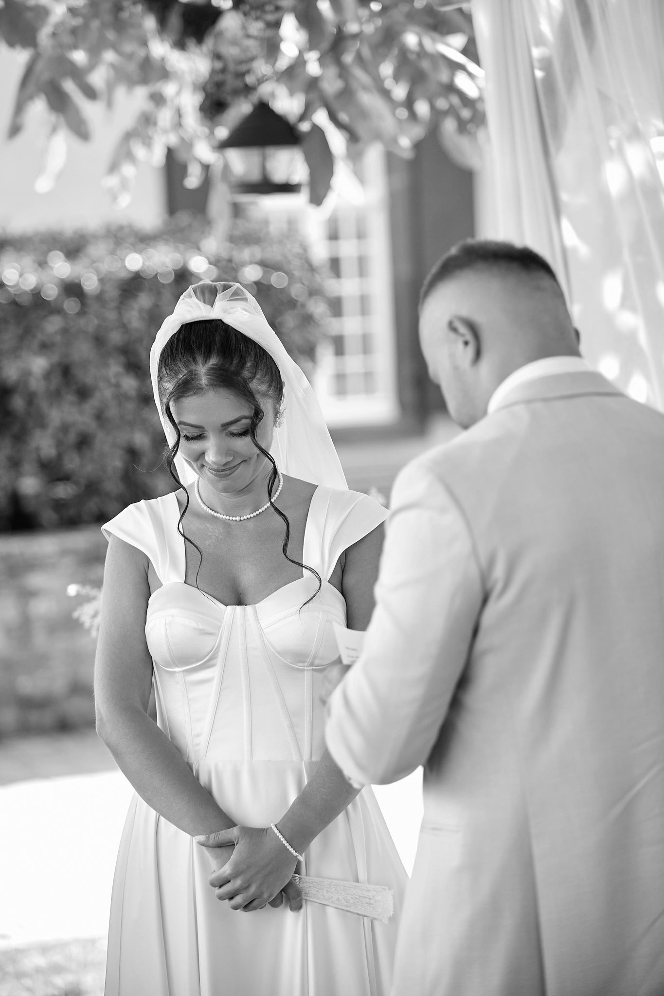 Intimate wedding ceremony moments captured in white outdoor pavilion setting.