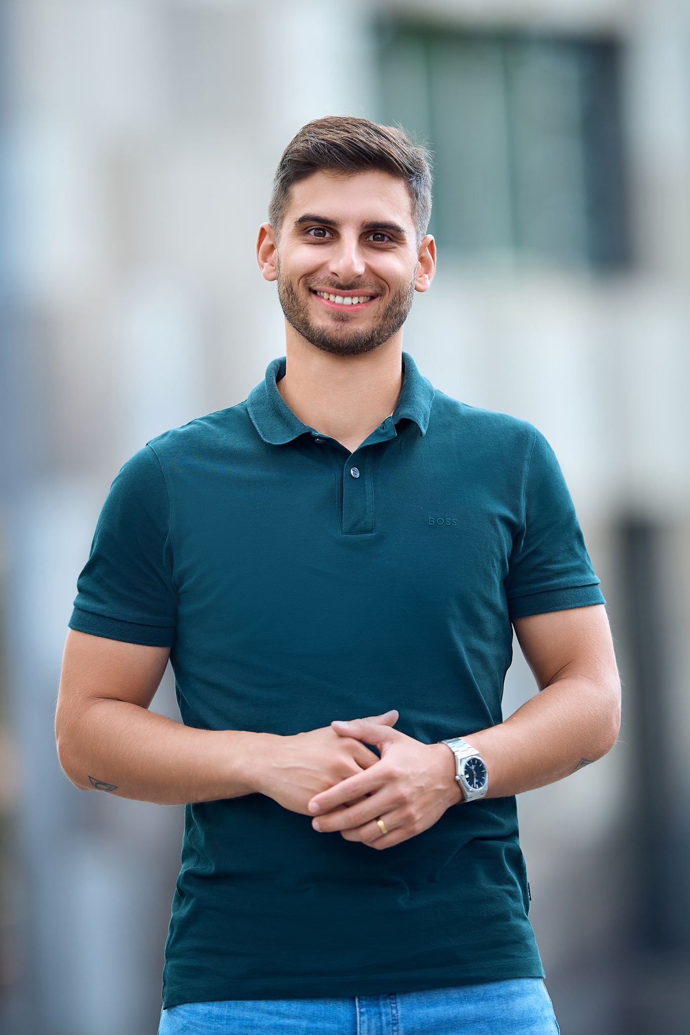 Casual outdoor portrait in dark teal polo shirt with natural lighting.