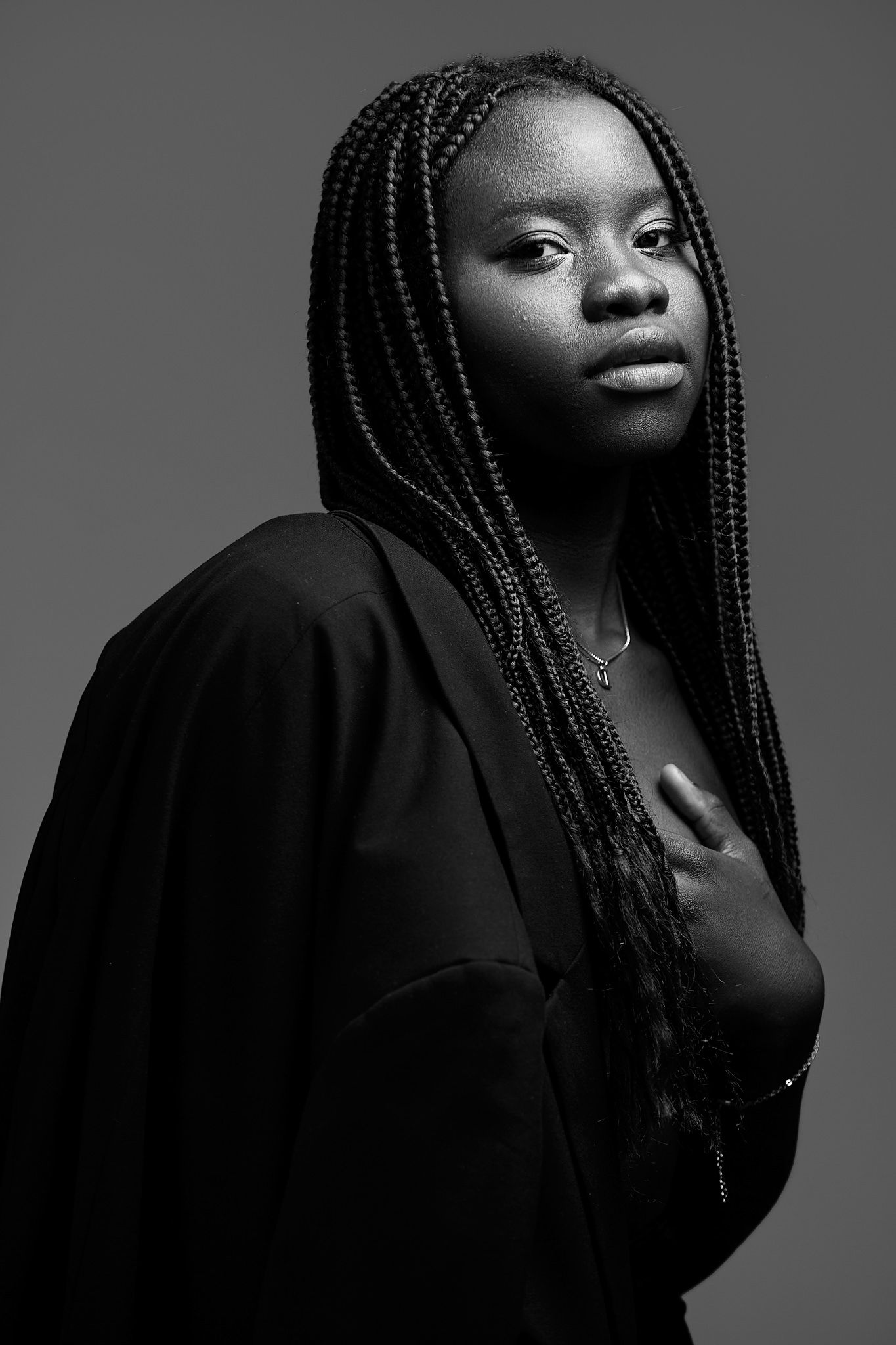 Artistic black and white portrait series with braided hair and dark clothing.