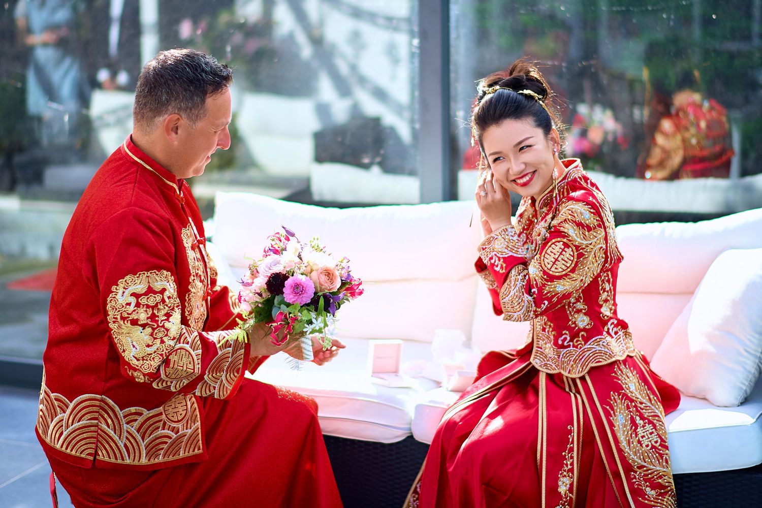 Elegant red and gold traditional wedding attire photographed in outdoor setting.