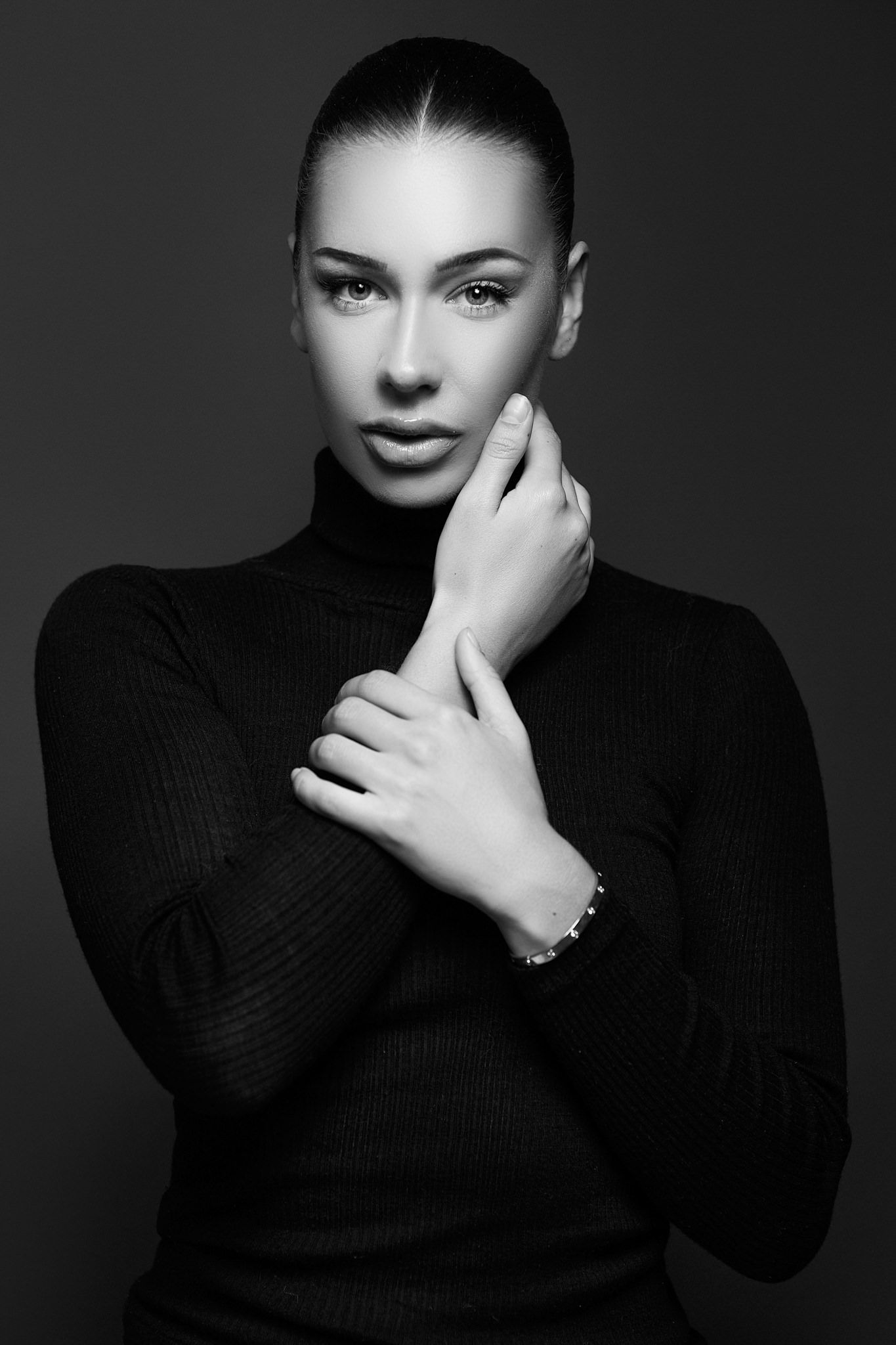 Dramatic black and white portrait series in turtleneck with artistic hand gestures.