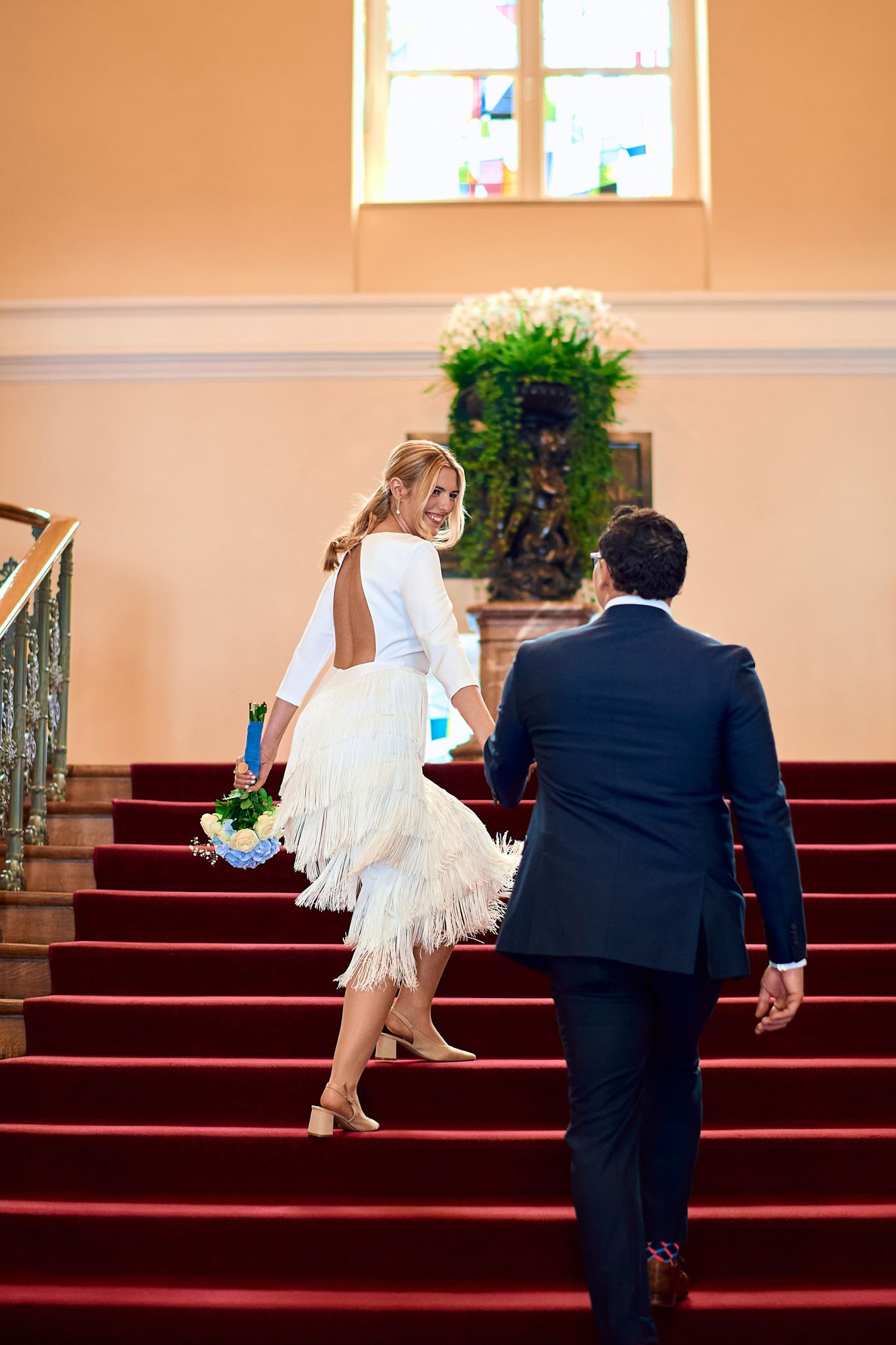 A sequence showing a couple ascending red-carpeted church steps during their wedding ceremony.