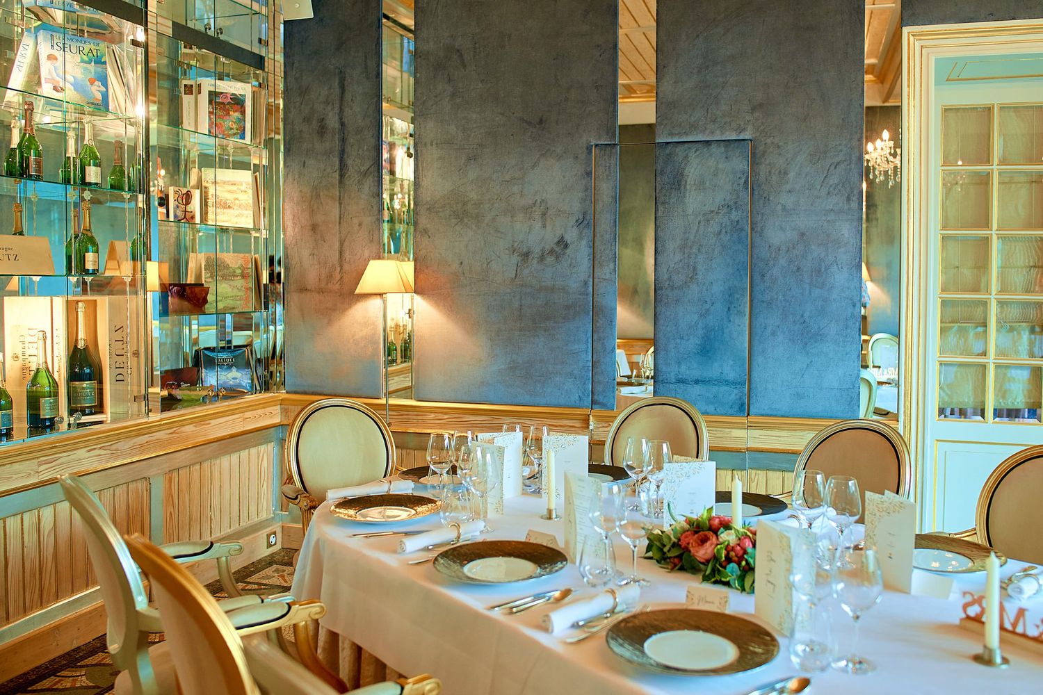 Elegant wedding reception table setting with glassware and warm lighting.