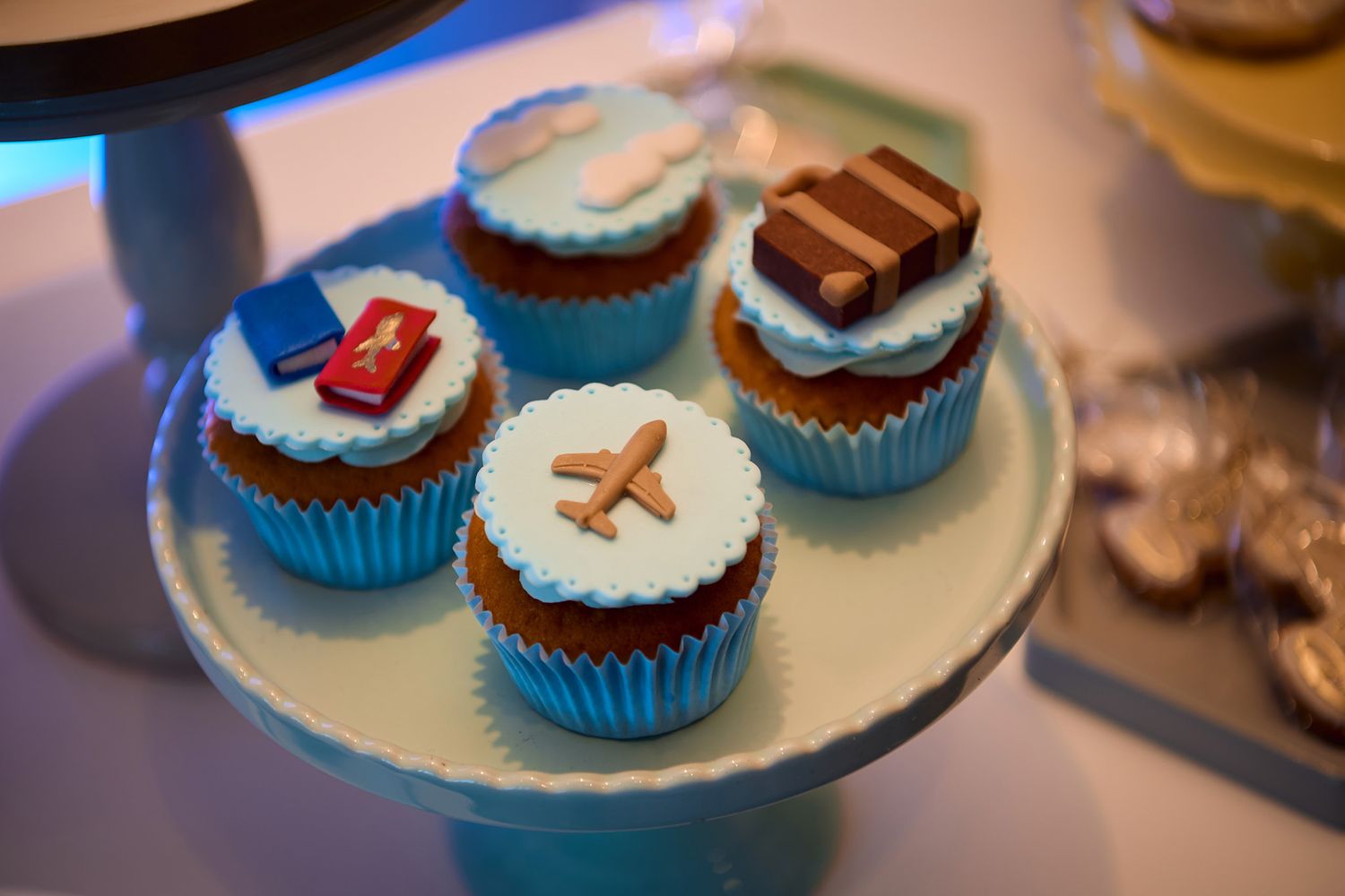 Decorative cupcakes with blue frosting displayed on white plate.