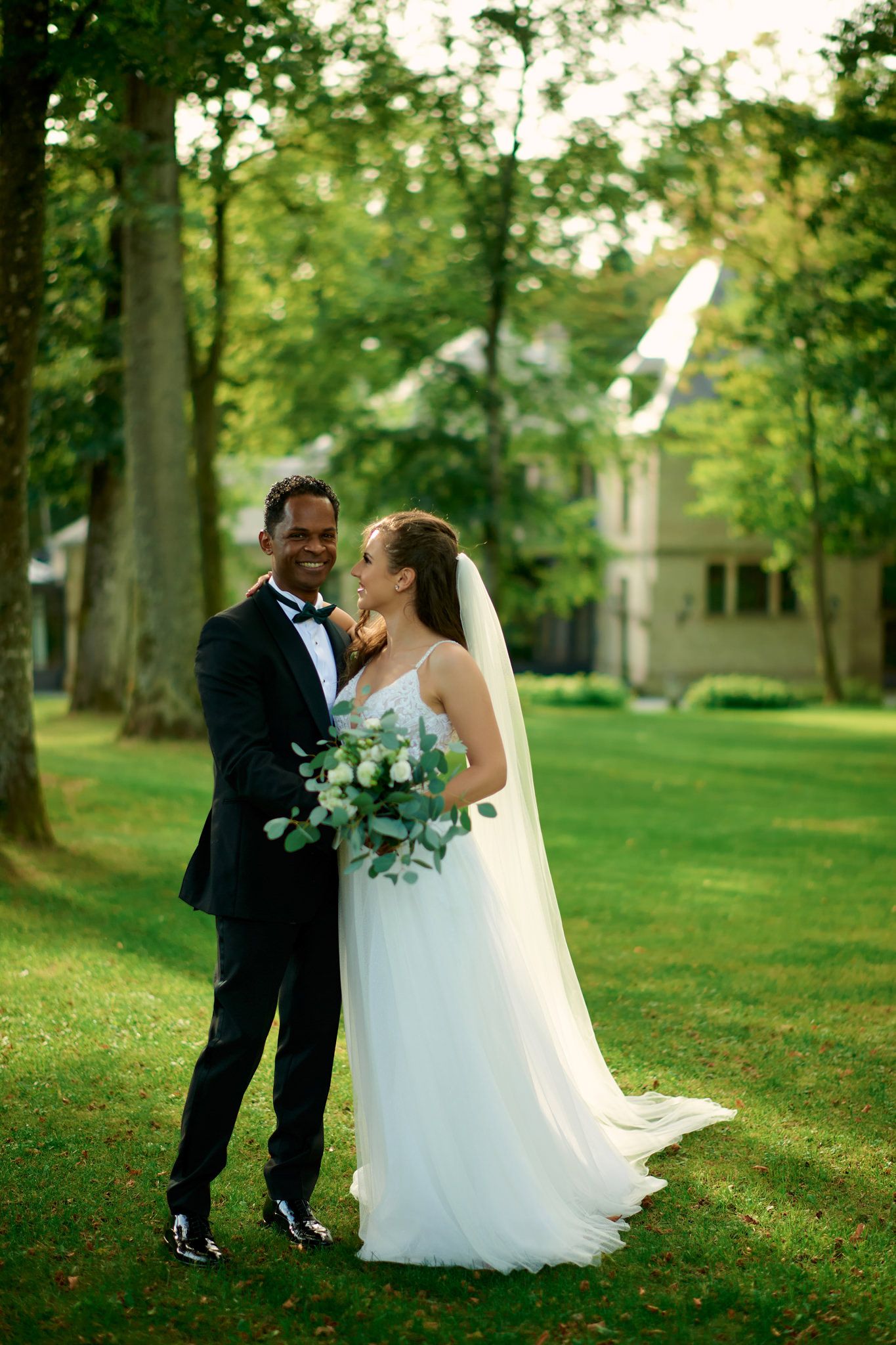 Candid wedding moments captured in a sunlit garden setting with trees.