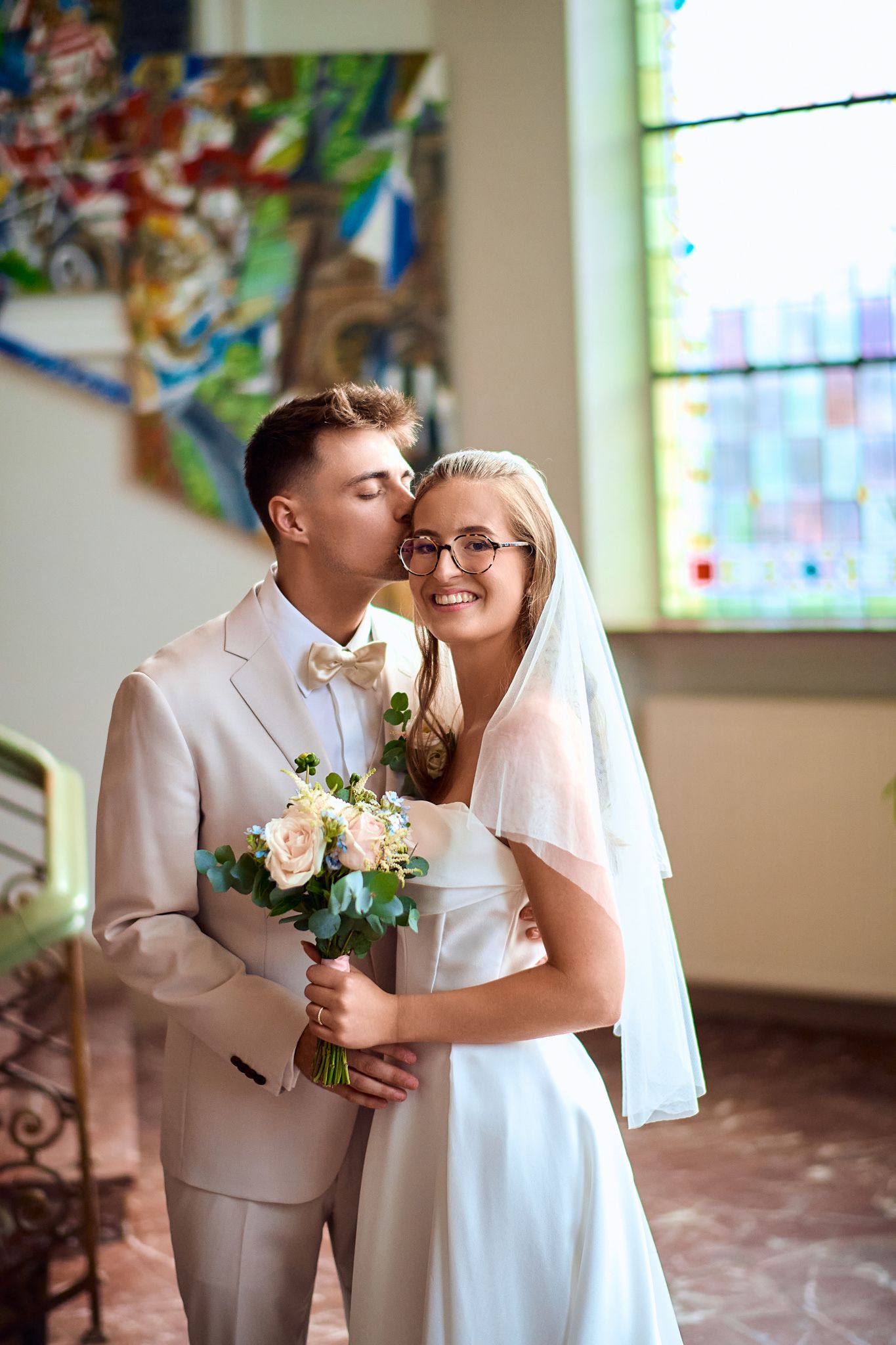 A series of romantic wedding photos showing a couple in white and beige attire sharing tender moments in a church.