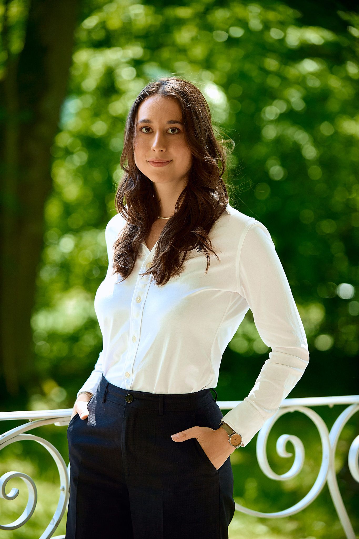 Stylish black and white outfit photographed against lush green garden background.