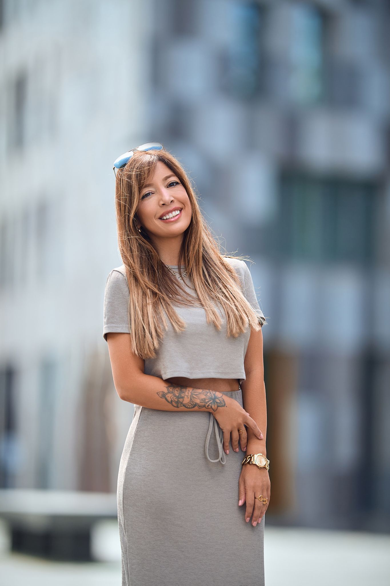 Casual portrait session in grey dress against modern architectural background.
