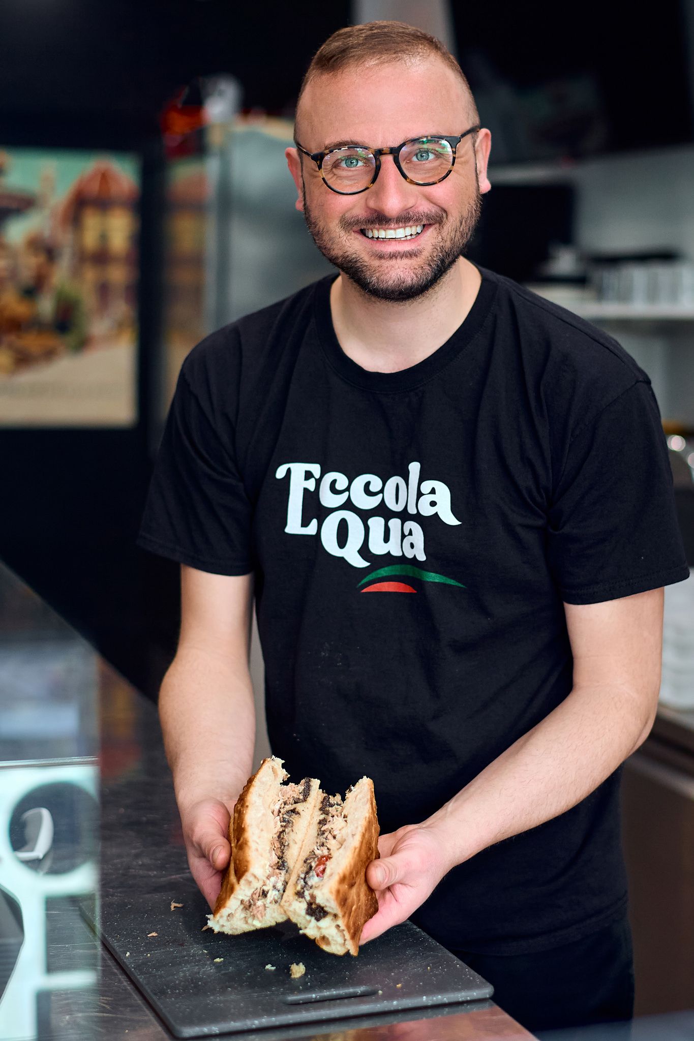 Restaurant worker in black t-shirt showing sandwich preparation sequence.