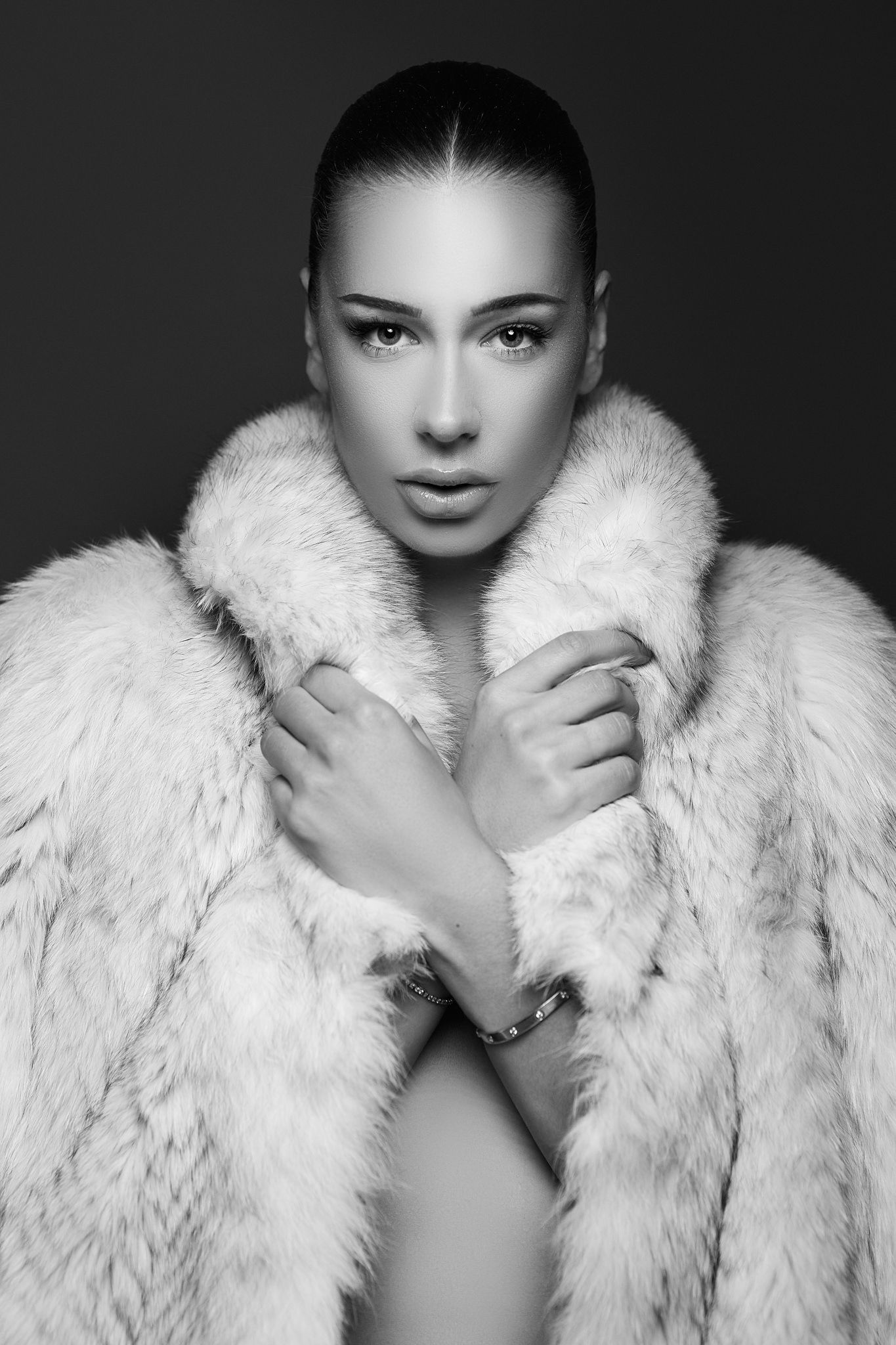 High contrast black and white portraits wearing luxurious white fur coat.