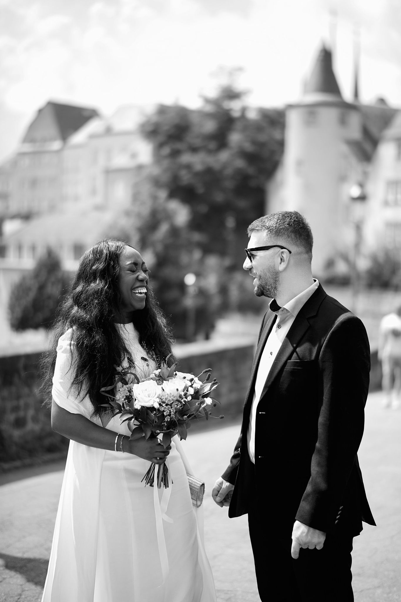 Black and white wedding photos showing joyful moments between newlyweds outdoors.