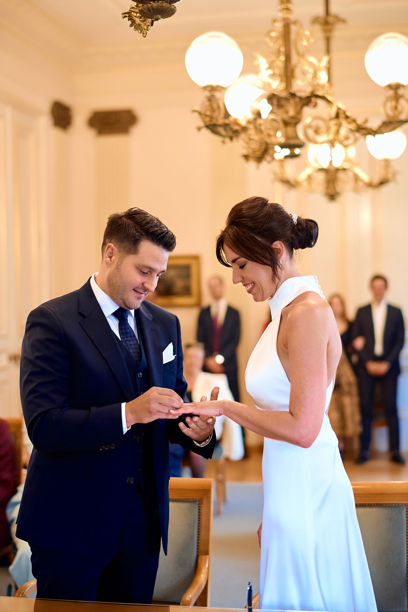 Couple exchanges rings during an intimate indoor wedding ceremony.