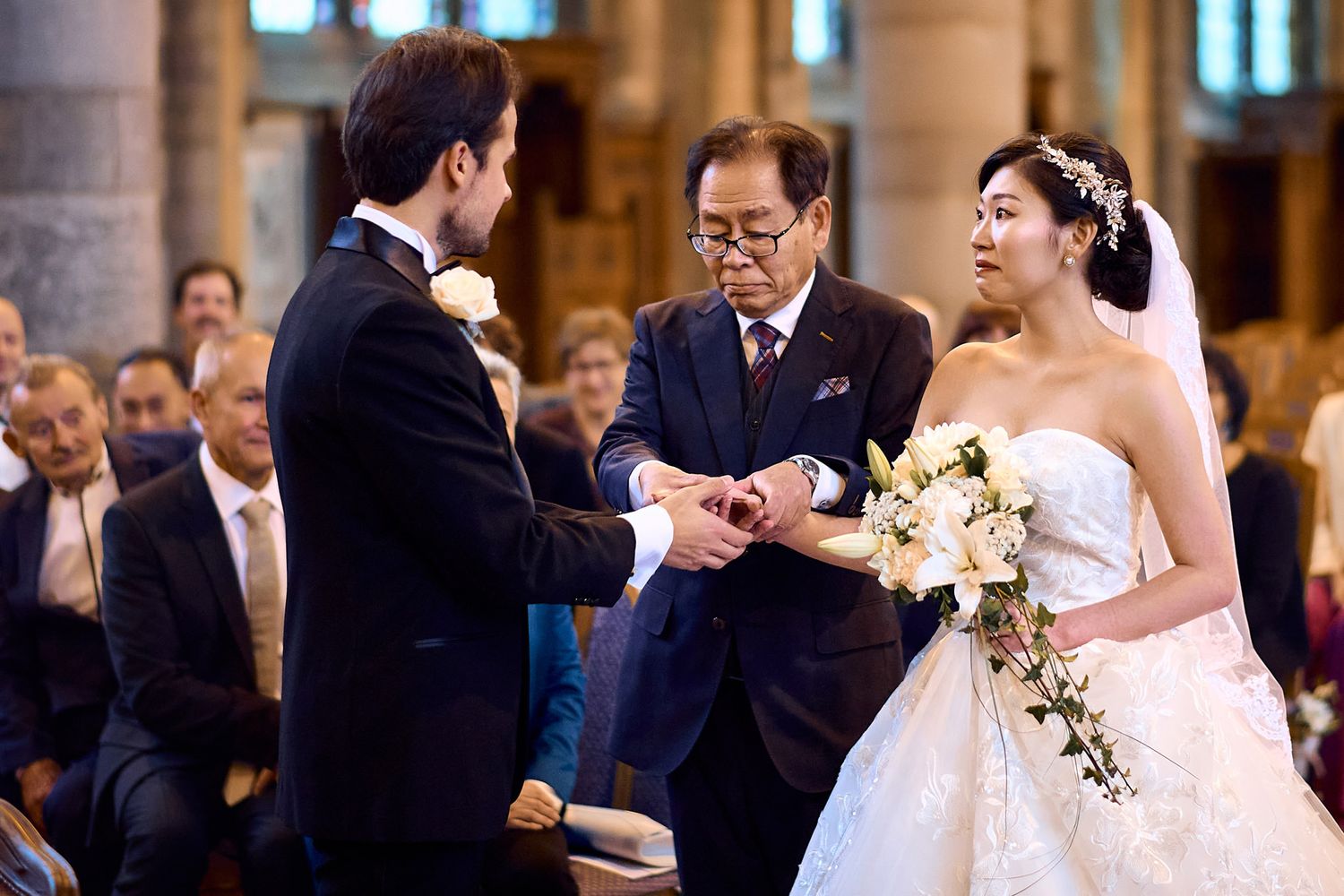 Wedding ceremony taking place in an ornate church with traditional decor.
