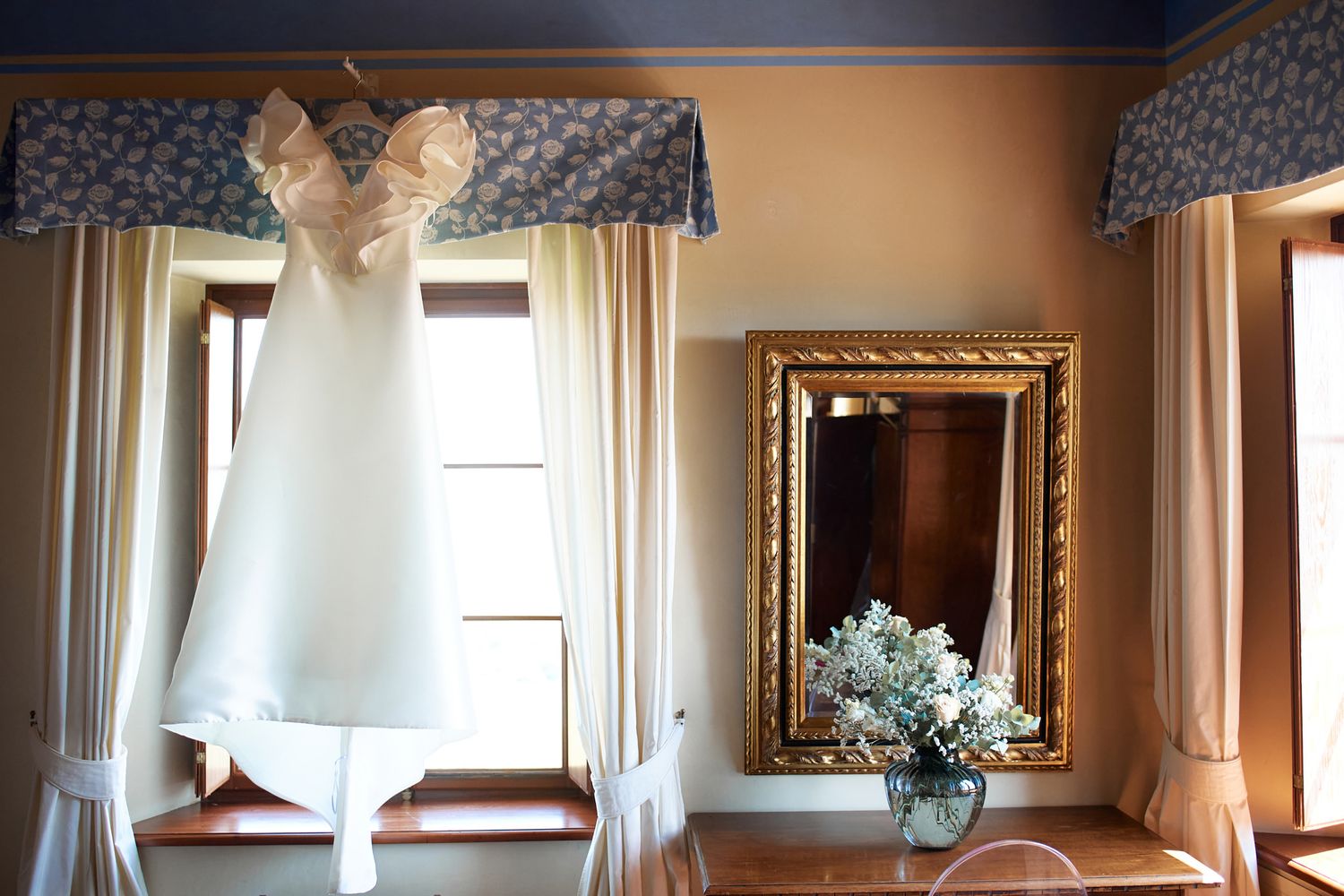 A panoramic view of an elegant room with ornate mirrors and blue walls.
