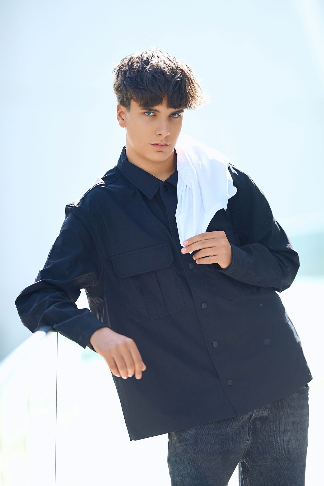 Fashion model poses in black outerwear against white background in multiple dynamic angles.