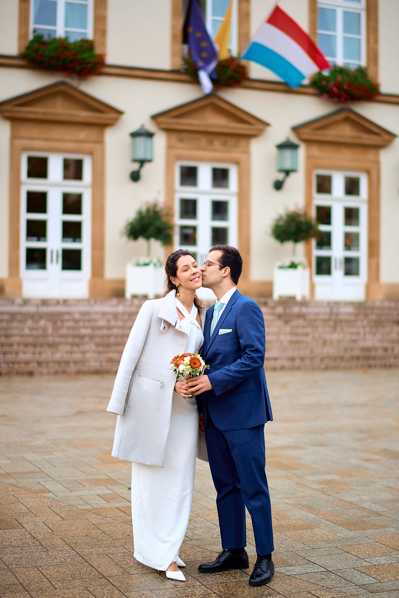 Candid wedding sequence showing couple dancing and laughing in front of historic building.