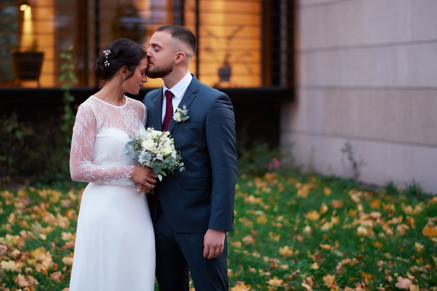Intimate wedding portrait with autumn leaves in the background.