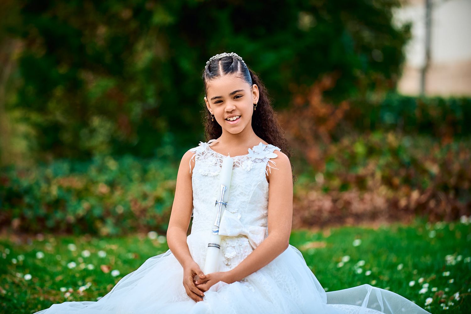Girl in white dress poses on grass during outdoor photo session.
