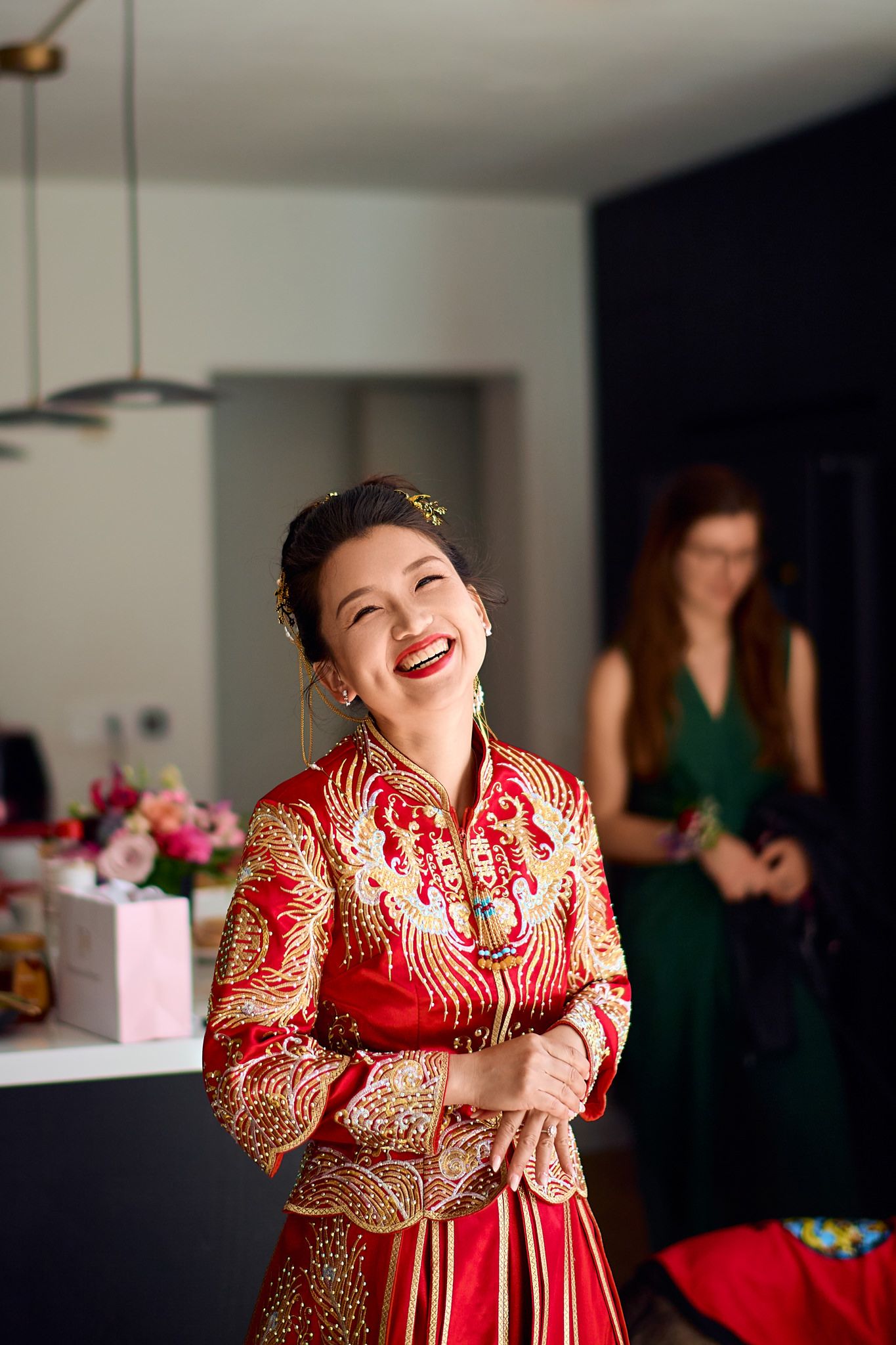 Joyful moments captured in traditional red and gold wedding attire during celebration.