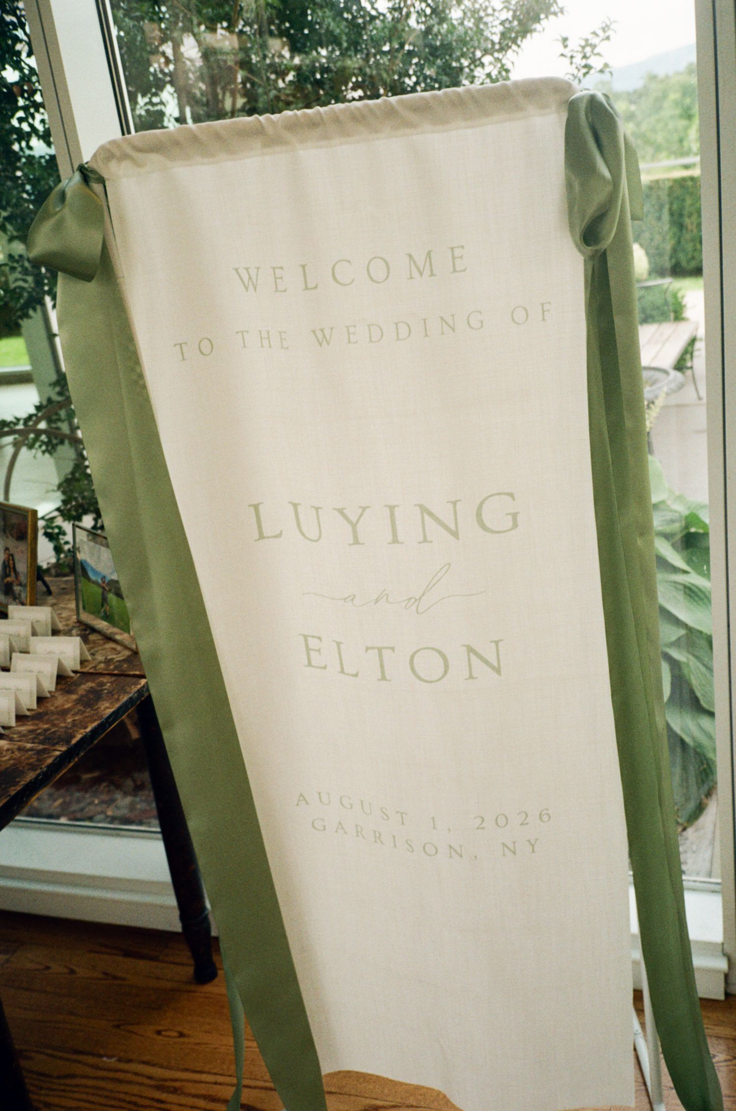 Elegant cream and sage green wedding welcome banner for Luying and Elton, August 5, 2026, Garrison NY.
